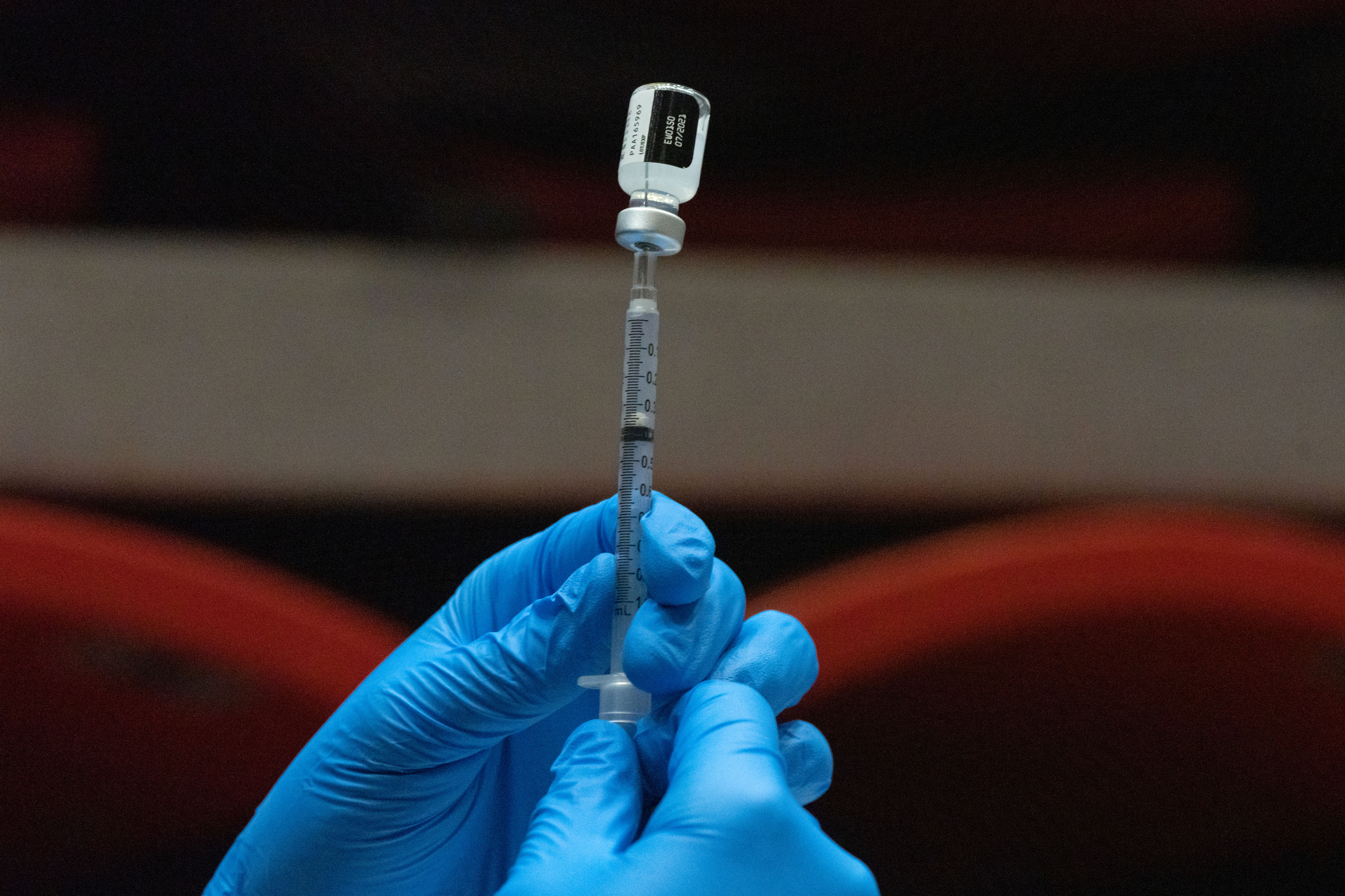 A health care worker prepares a dose of the Pfizer/BioNTech Covid-19 vaccine in San Diego on April 1.