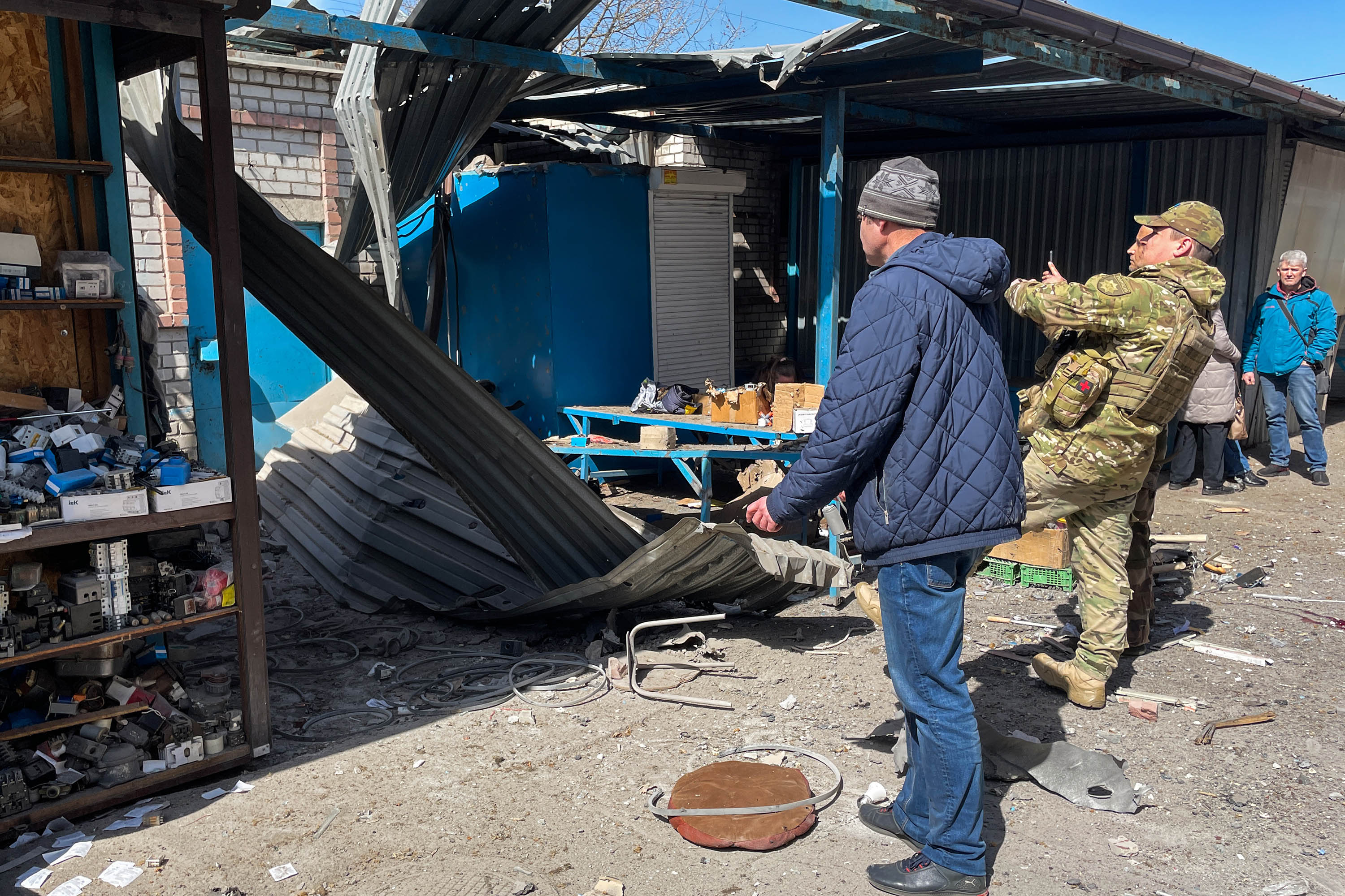 People view the damage at a market that was shelled by Russian forces, in Kherson, Ukraine, on April 18. 