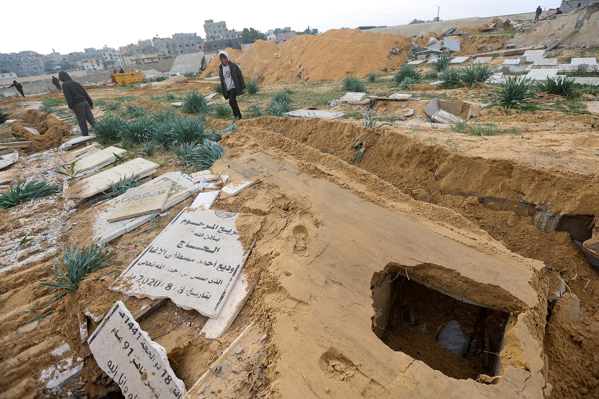 Palestinians check damaged graves at a cemetery following an Israeli raid in Khan Younis, Gaza, on January 17.