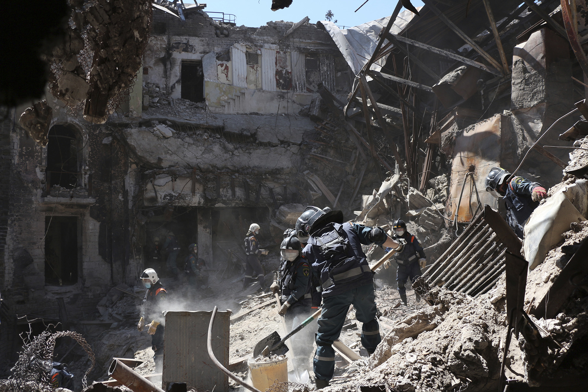 Donetsk People Republic Emergency Situations Ministry employees clear rubble at the side of the damaged Mariupol Theater in Mariupol, Ukraine, on May 12.