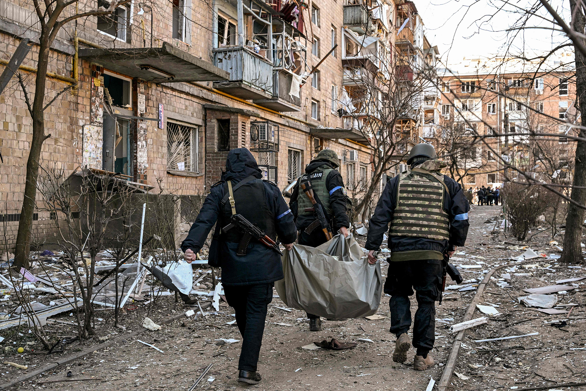 Ukrainian policemen carry a body after a residential building was hit by shelling in Kyiv, Ukraine on March 18.