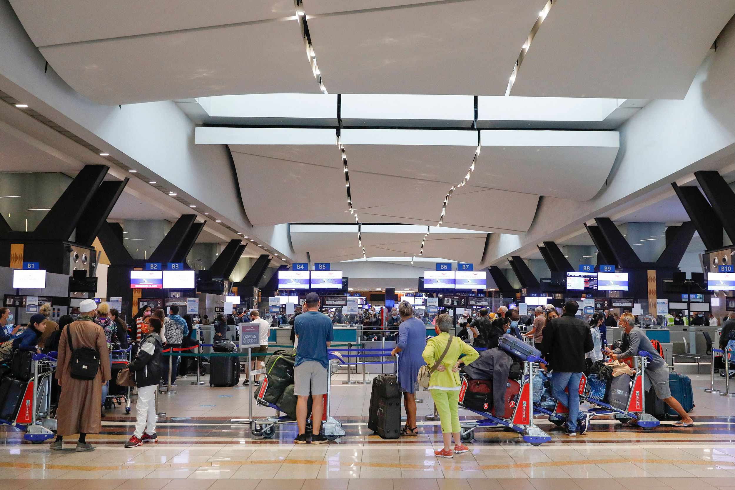Travelers queue at a check-in counter at OR Tambo International Airport in Johannesburg on November 27.