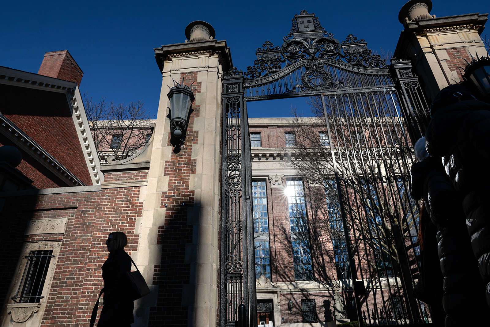 A pedestrian passes a gate to Harvard Yard on Massachusetts Ave. in Cambridge, MA, on December 12.