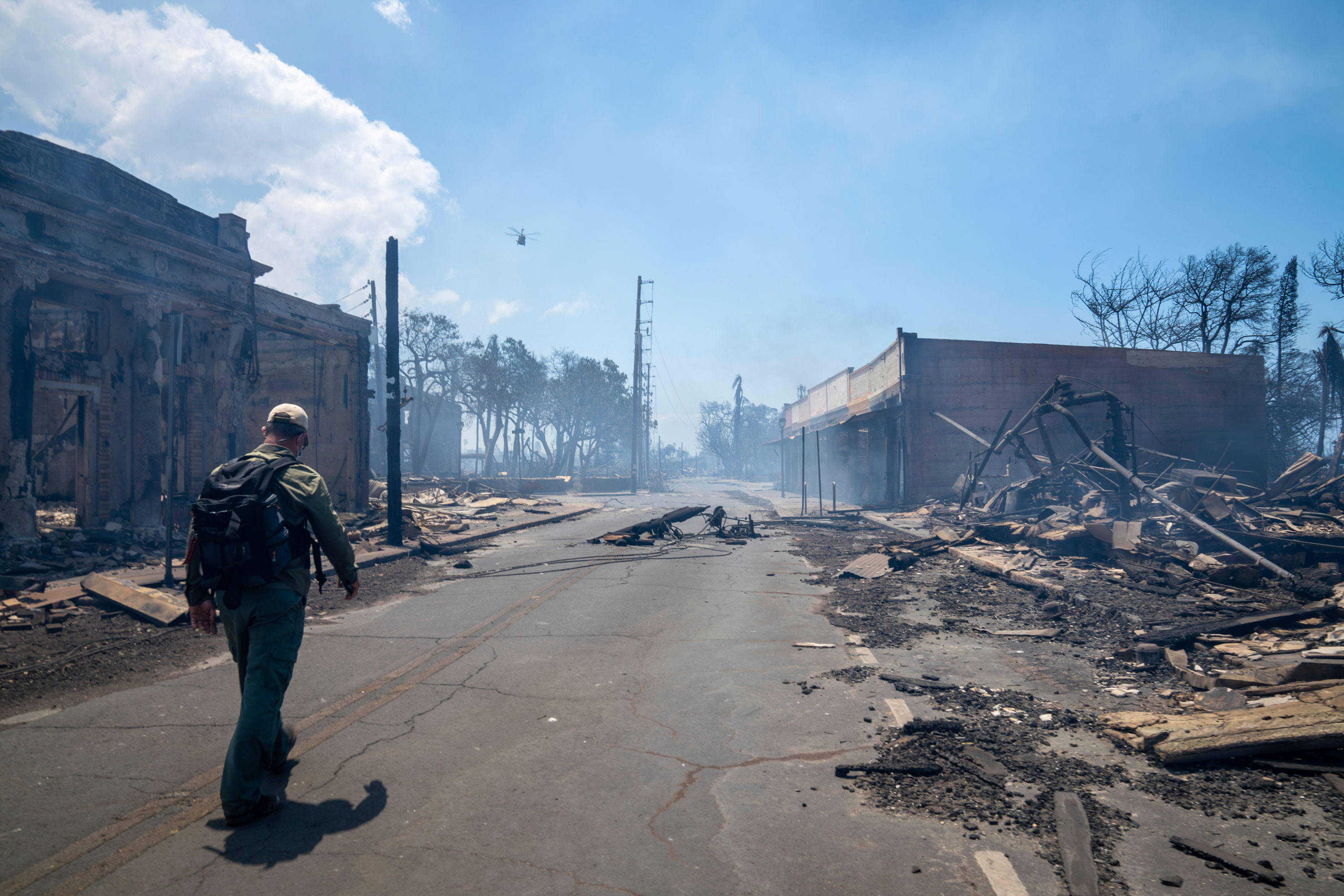 A man walks past wildfire damage in Lahaina, Hawaii, on Wednesday.