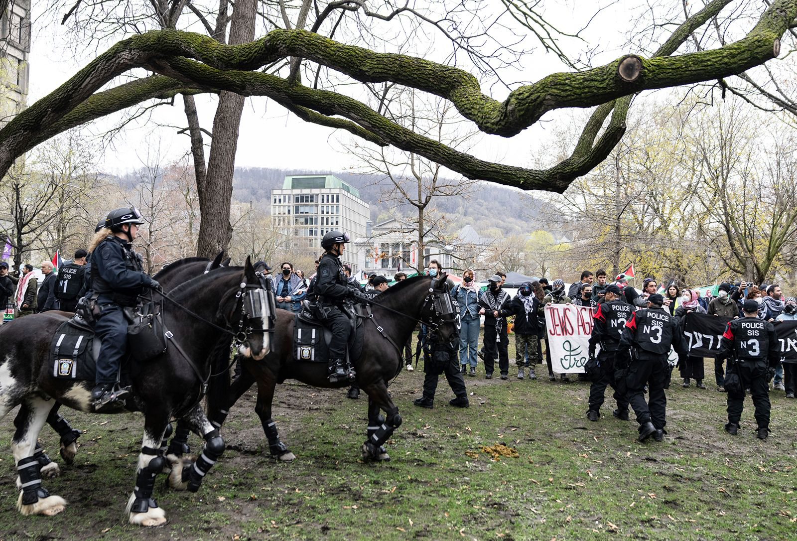 Mounted police officers walk past as pro-Palestinian activists at an encampment set up on McGill University's campus in Montreal, on May 2.