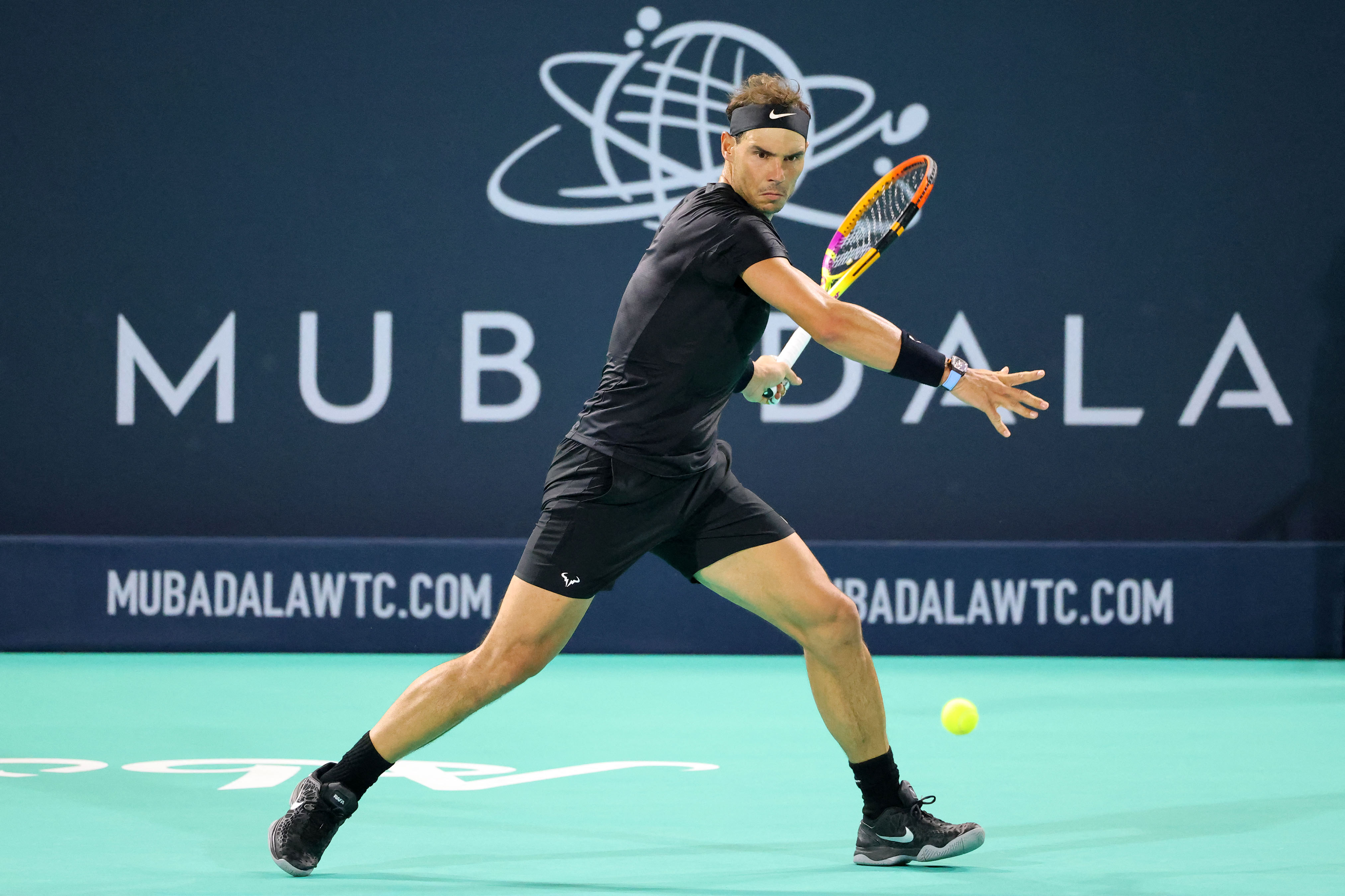 Spain's Rafael Nadal returns the ball to Canada's Denis Shapovalov (unseen) during the third-place play-off match of the Mubadala World Tennis Championship in the Gulf emirate of Abu Dhabi on December 18, 2021. 