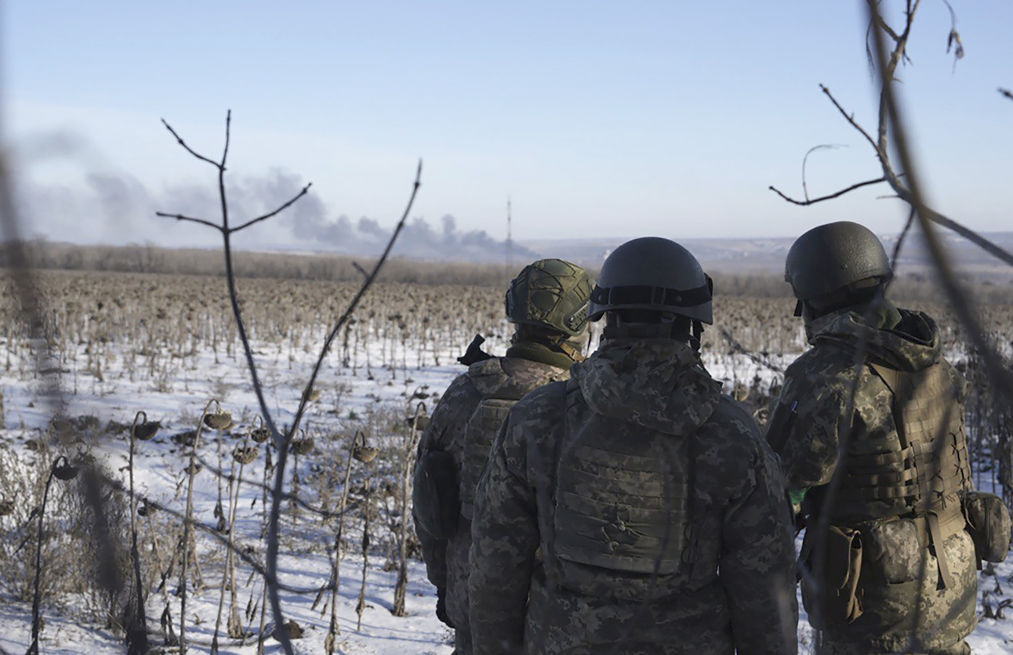 Ukrainian soldiers watch as smoke billows during fighting between Ukrainian and Russian forces in Soledar, Donetsk region, Ukraine, on January 11.