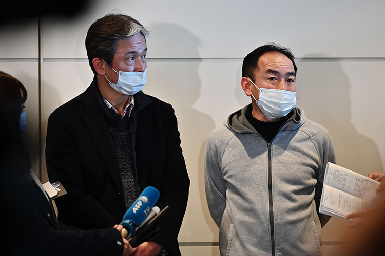 Takeo Aoyama and Takayuki Kato speak to journalists following their charter flight arranged by Japan's government to evacuate Wuhan at Haneda airport in Tokyo.
