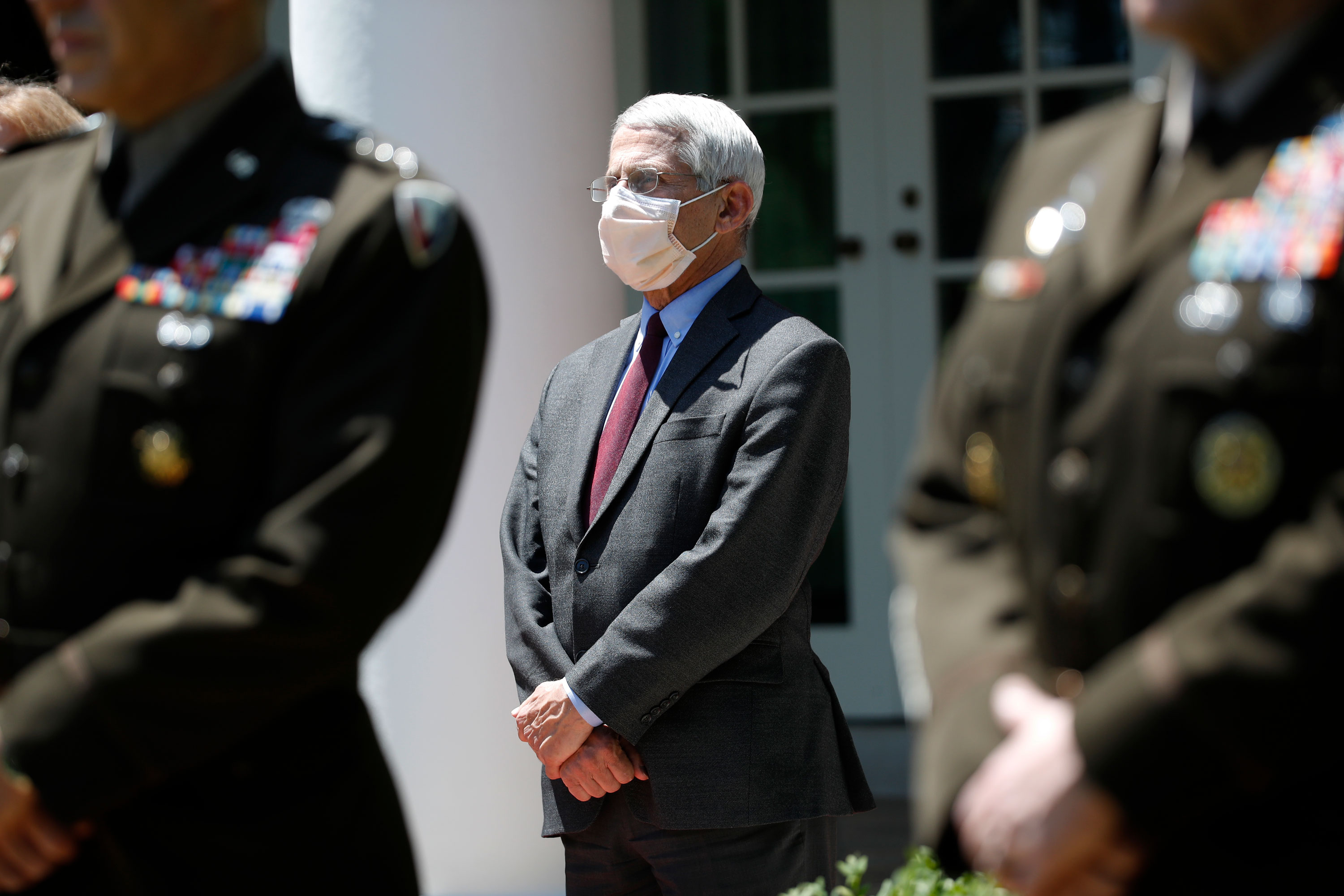 Dr. Anthony Fauci, director of the National Institute of Allergy and Infectious Diseases, listens as President Donald Trump speaks about the coronavirus in the Rose Garden of the White House on May 15 in Washington. 