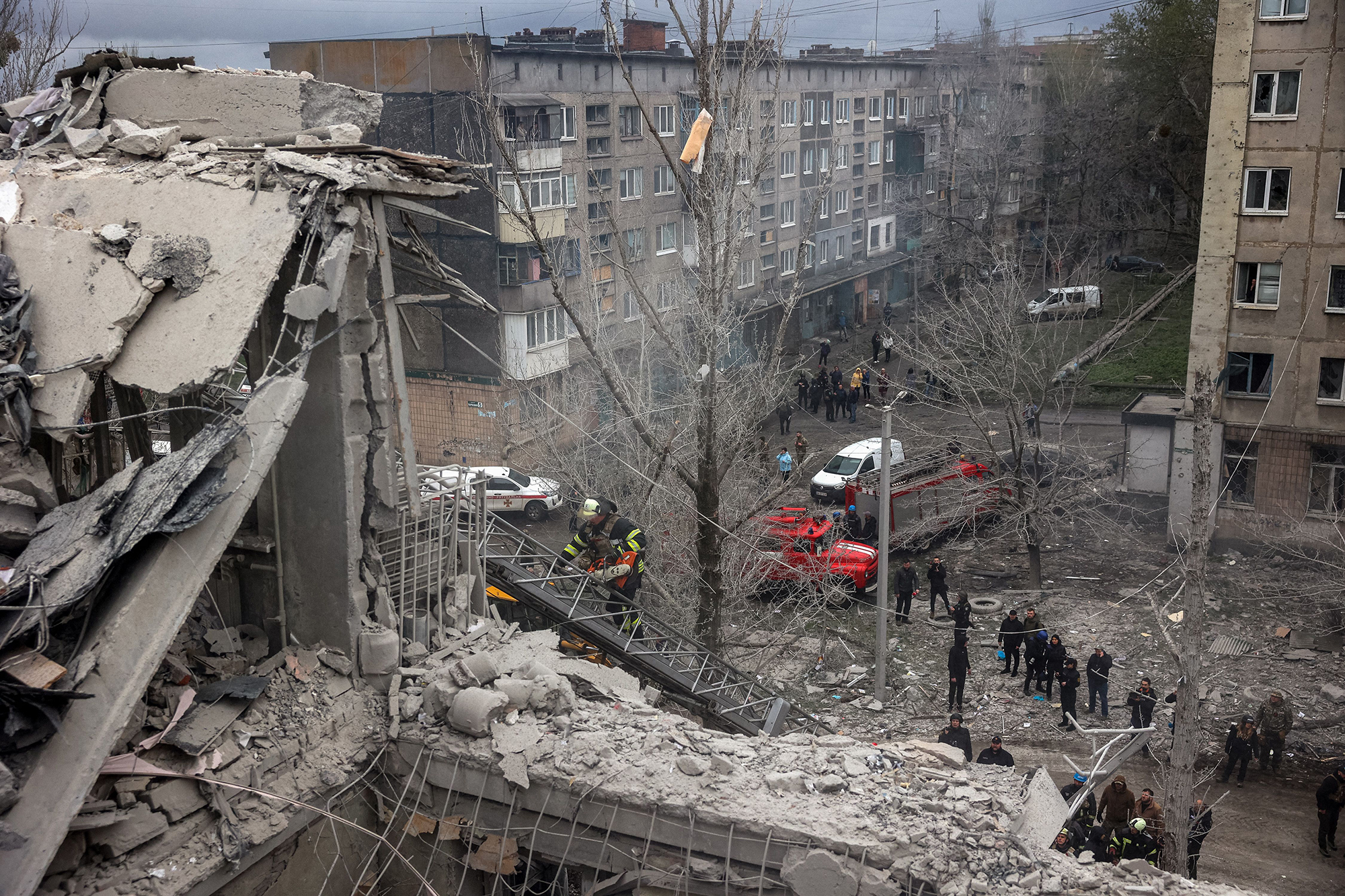 People stand around a partially destroyed residential building in Sloviansk, Ukraine, on April 14. 