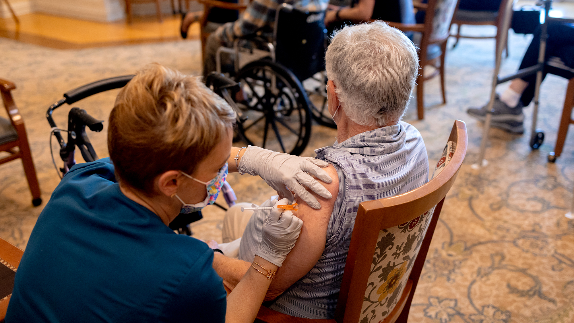 A healthcare worker administers a third dose of the Pfizer-BioNTech Covid-19 vaccine at a senior living facility in Worcester, Pennsylvania, on August 25. 