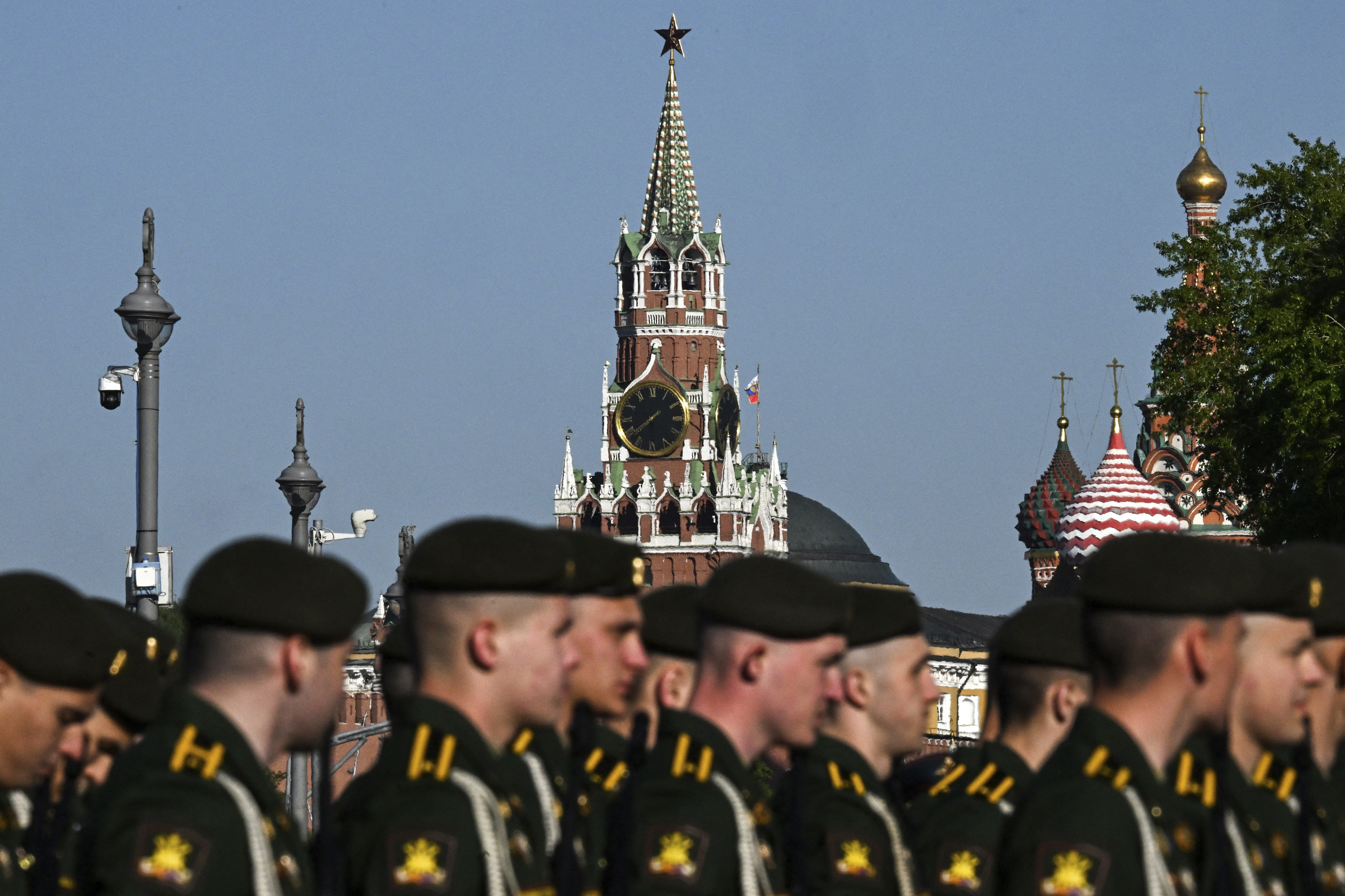 Russian servicemen are seen against the backdrop of the Kremlin and Saint Basil's cathedral during preparations for the Victory Day military parade rehearsal in Moscow, on Sunday, May 7.