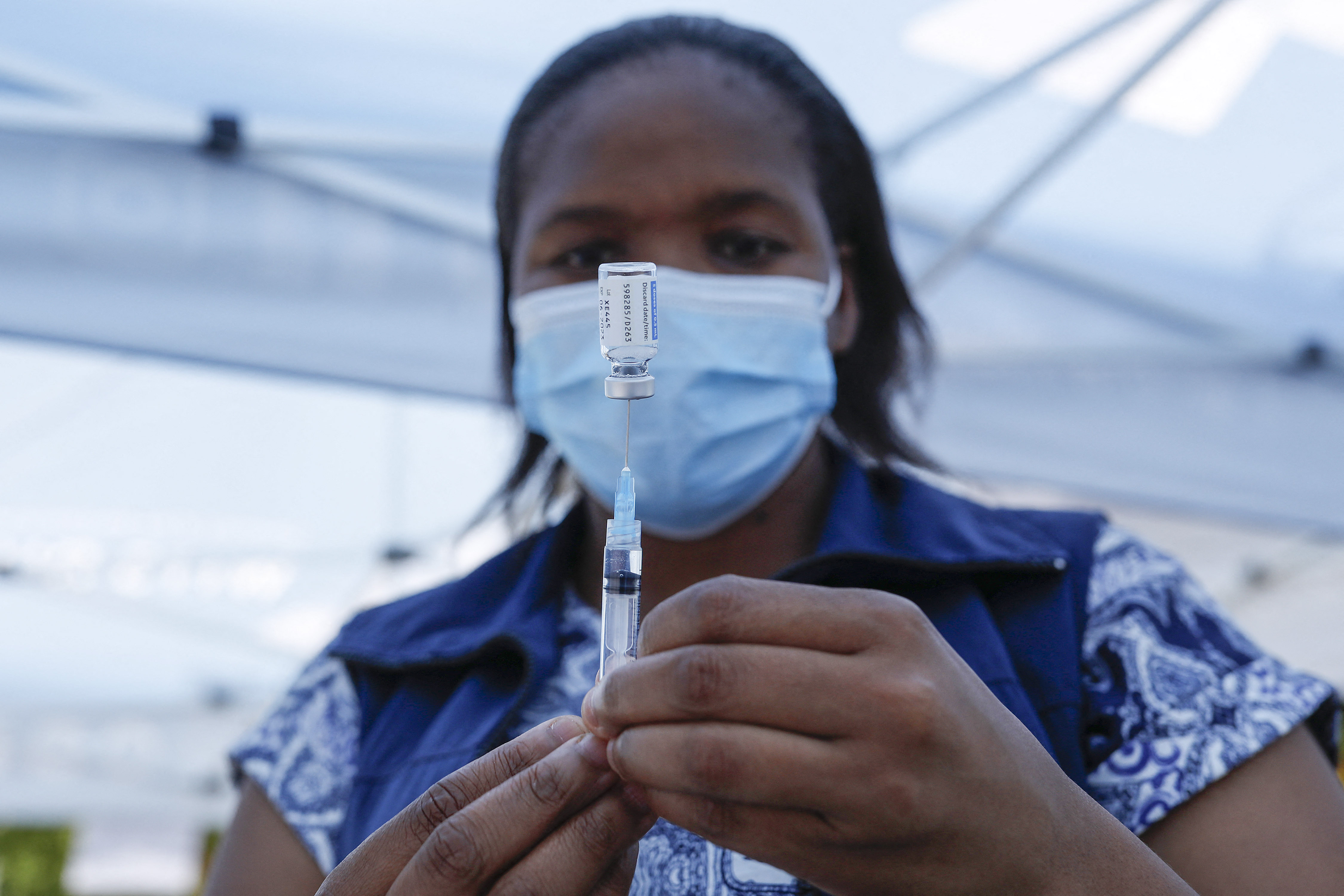 A healthcare prepares a dose of the Johnson and Johnson vaccine from a vial outside a polling station in Laudium, Pretoria, on November 1, 2021, during South Africa's local elections. 