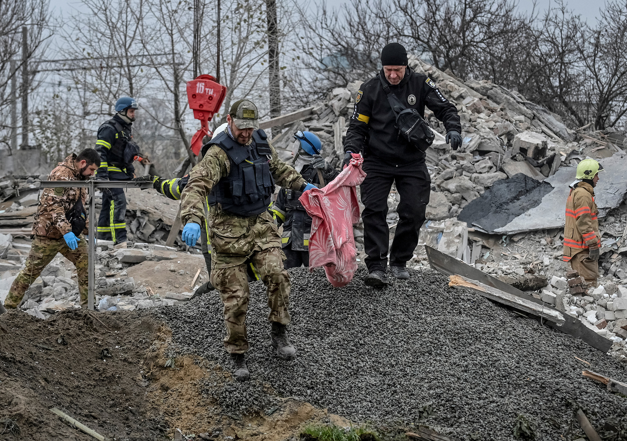 Police officers carry fragments of a body found under debris of a residential house destroyed by a Russian missile strike in the town of Vilniansk, Zaporizhzhia region, Ukraine, on November 17.
