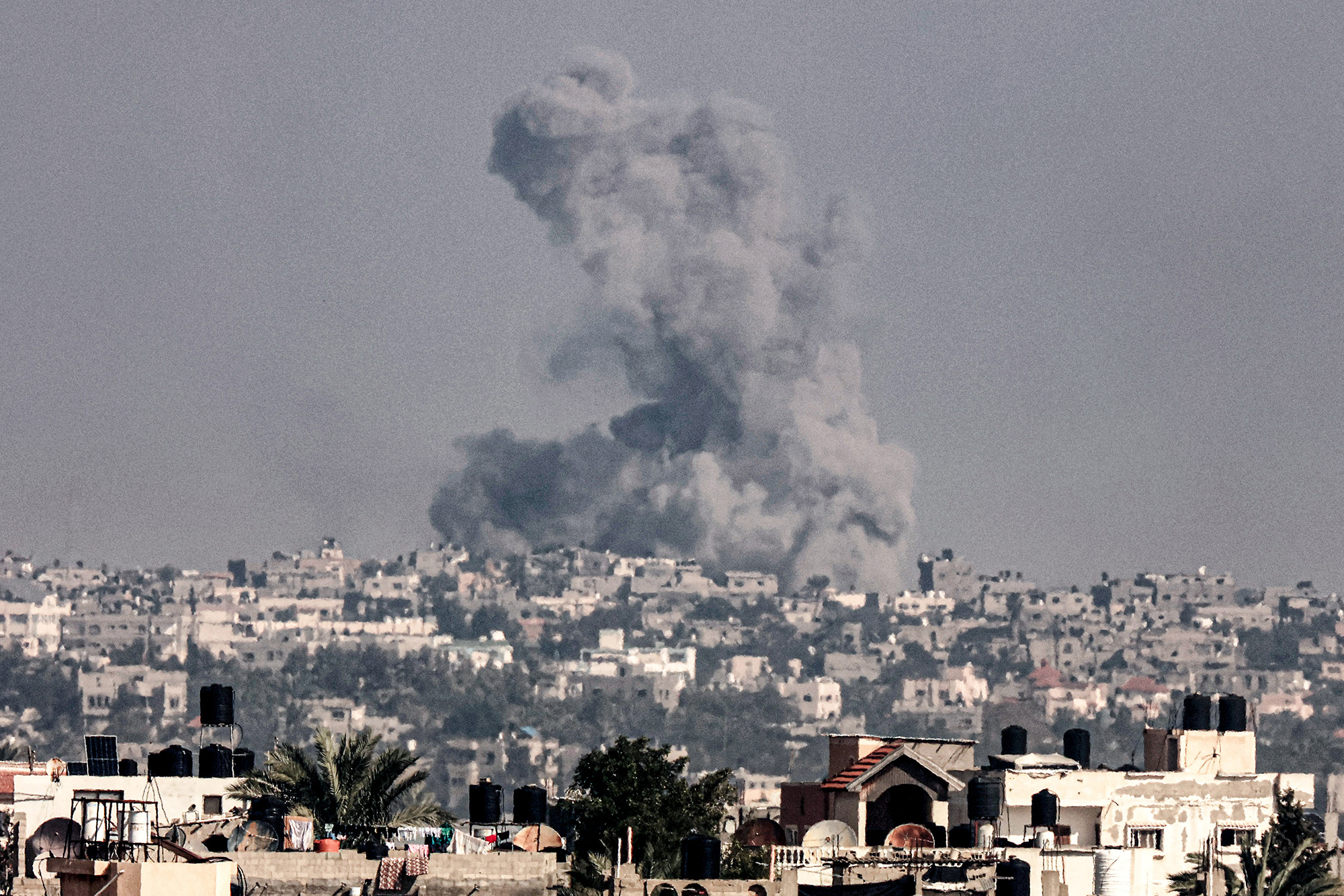 A picture taken from Rafah shows smoke billowing above buildings during Israeli bombardment in Khan Younis in the southern Gaza on December 8.