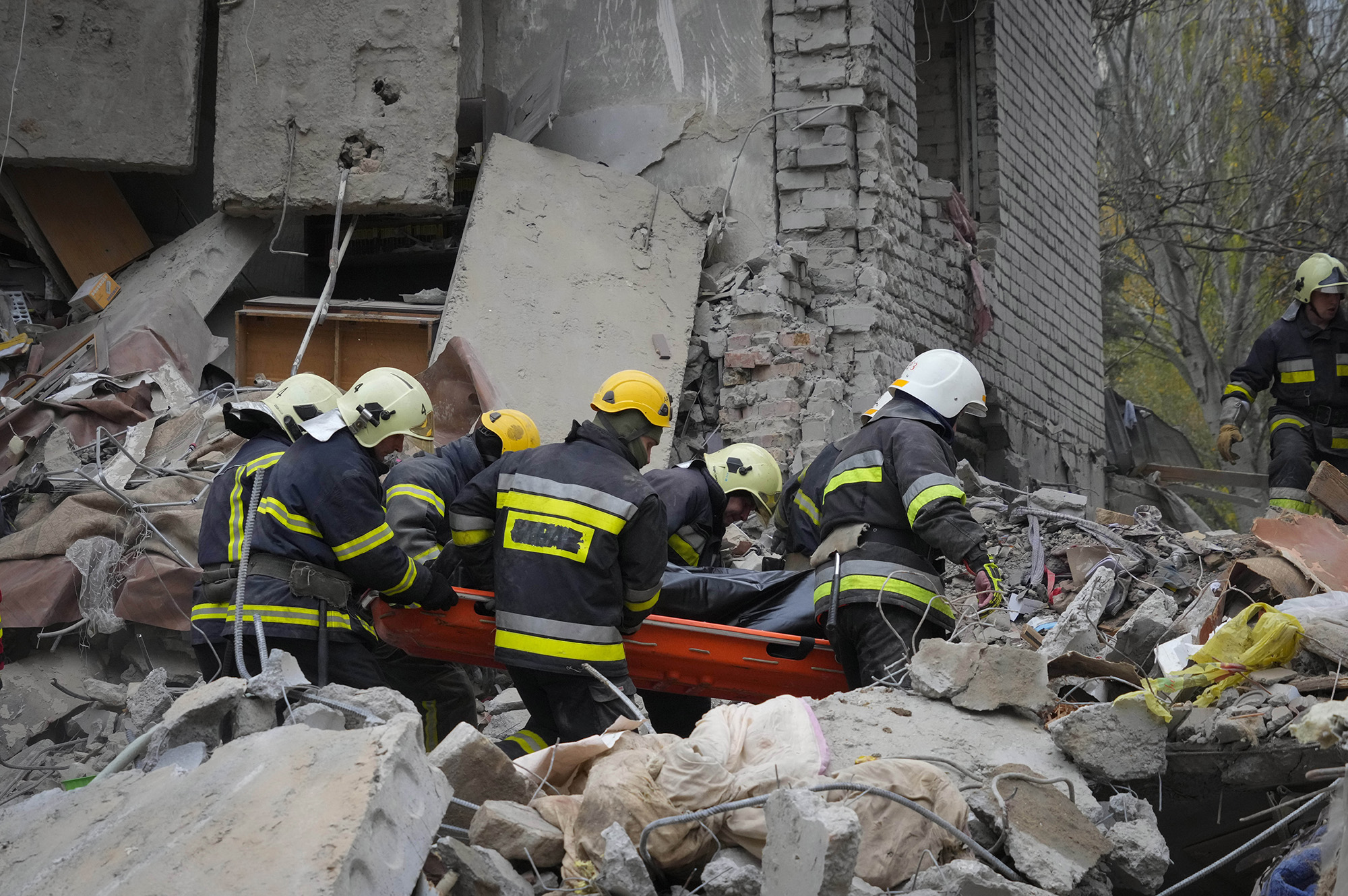 Ukrainian Emergency Service rescuers carry a body found under rubble at the scene of shelling in Mykolaiv, Ukraine, on November 11.