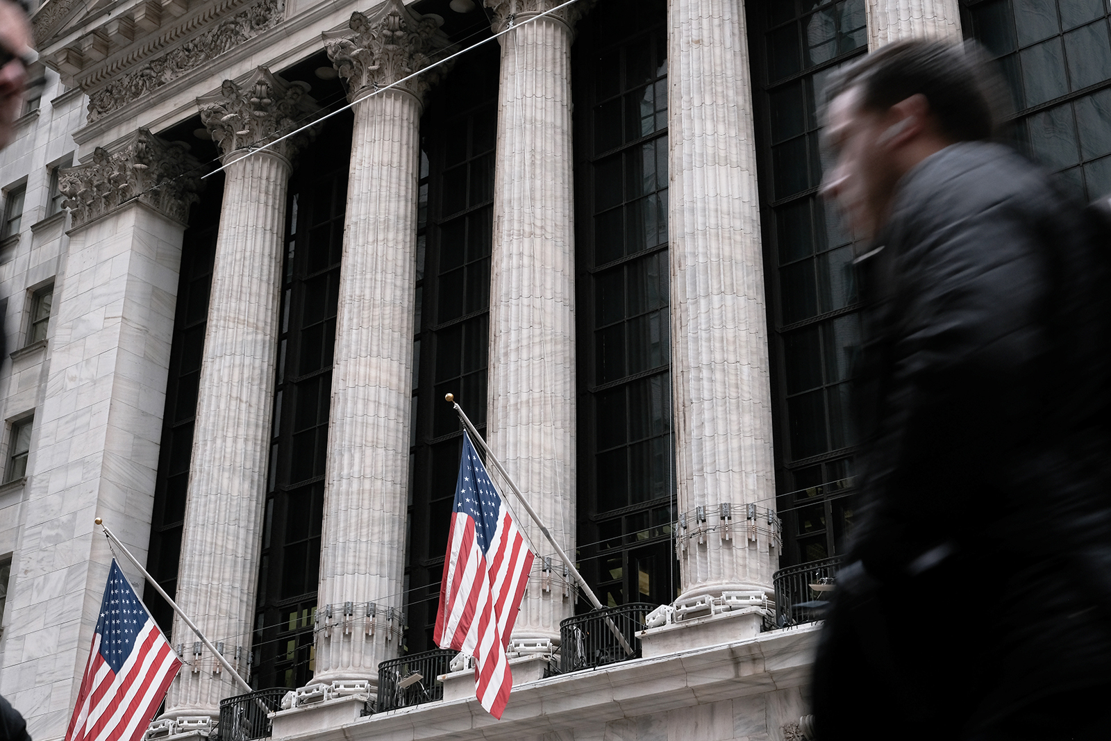 People walk past the New York Stock Exchange on March 16.