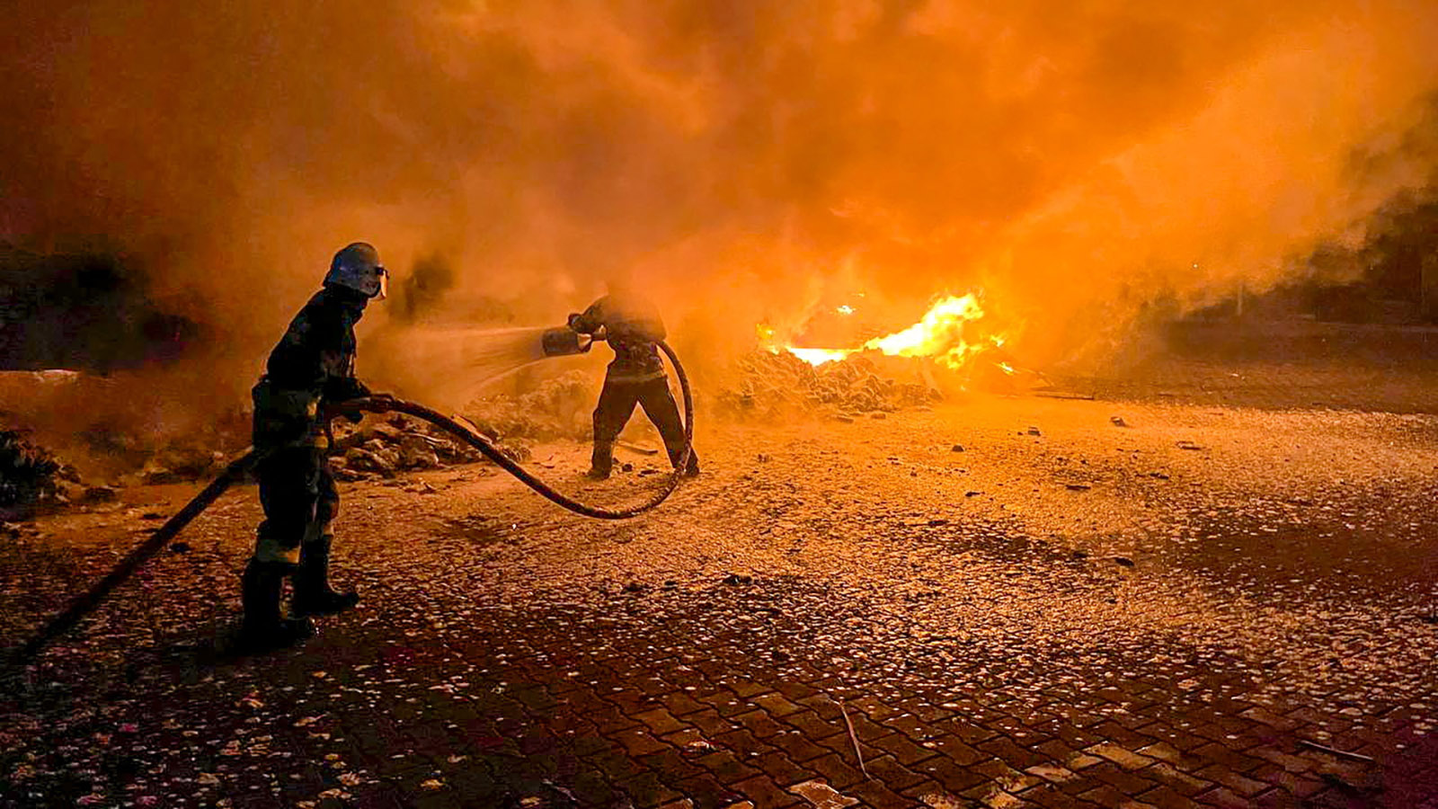 Firefighters work to extinguish burning trucks that were damaged during a Russian drone attack on a Danube river port compound in Ukraine's Odesa region on September 26. 
