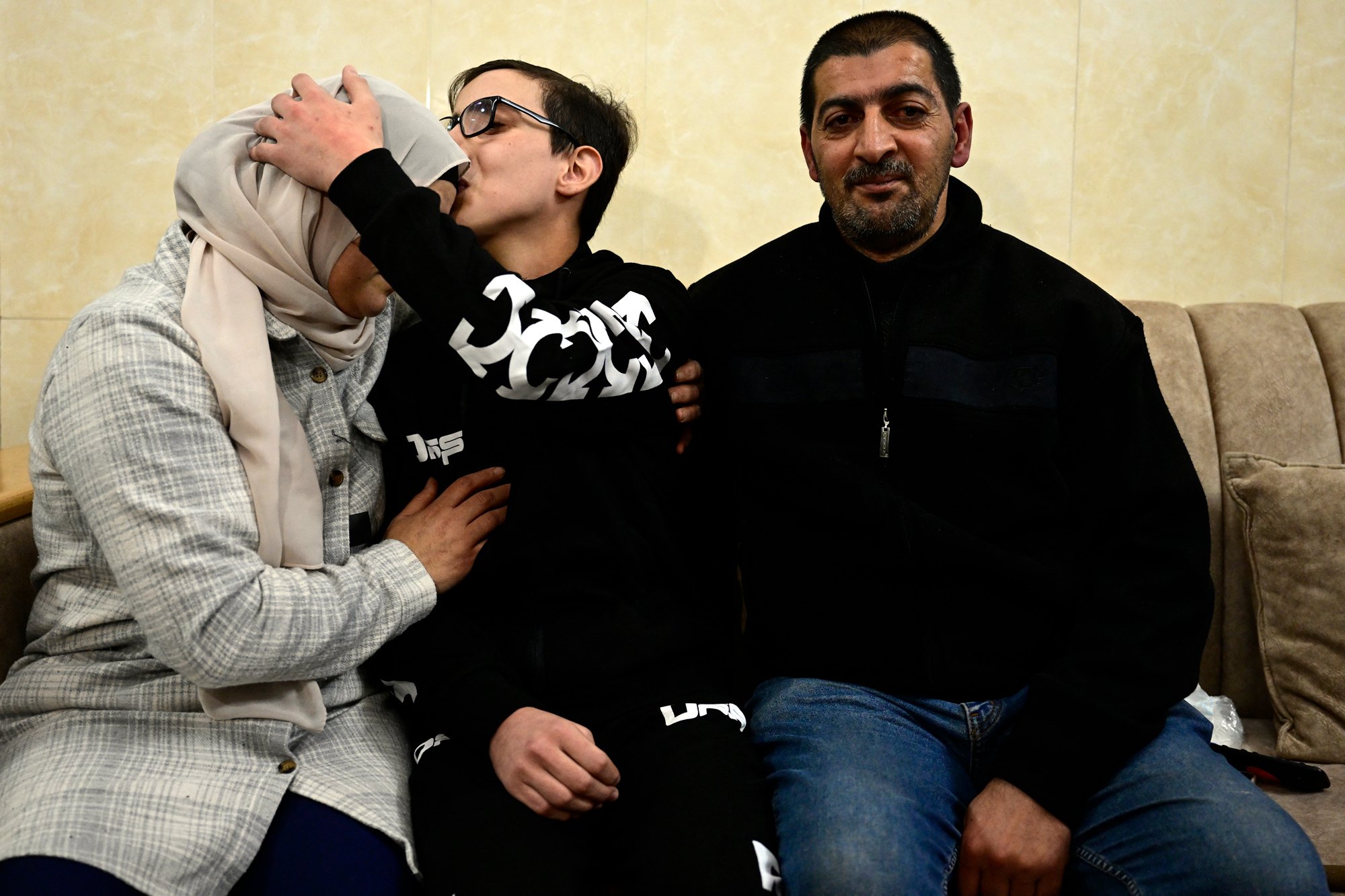 Moataz Salaima, 15, kisses his mother upon his arrival at his home in East Jerusalem on November 28, after 30 Palestinian detainees were released under an extended truce deal.