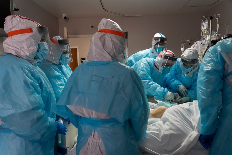 Medical staff members work to extract muscle sample from a patient for muscle biopsy examination in the Covid-19 intensive care unit at the United Memorial Medical Center on December 22, in Houston, Texas.