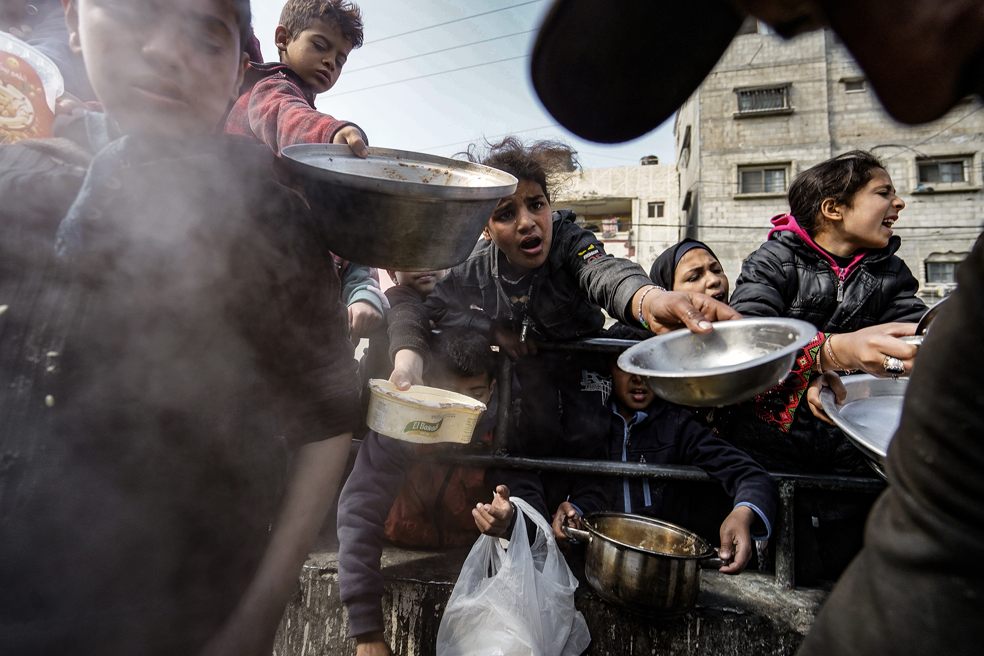 Children reach for food distributed by charities in Rafah, Gaza, on February 5.