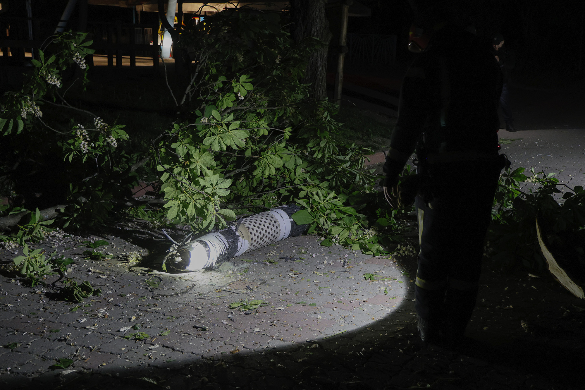 Police officers investigate fragments of a rocket that fell down in a city zoo after it was shot down by air defense system during the night in Kyiv, Ukraine, on May 16.