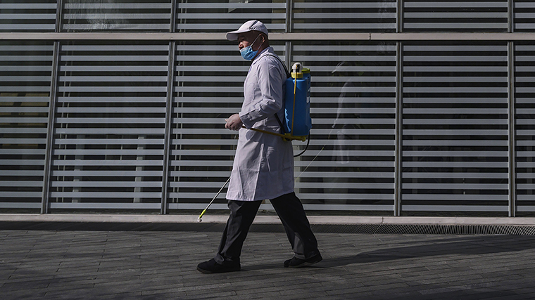 A Chinese worker wears a protective mask as he disinfects outside common areas at an office building on Sunday, February 10, 2020 in Beijing, China.