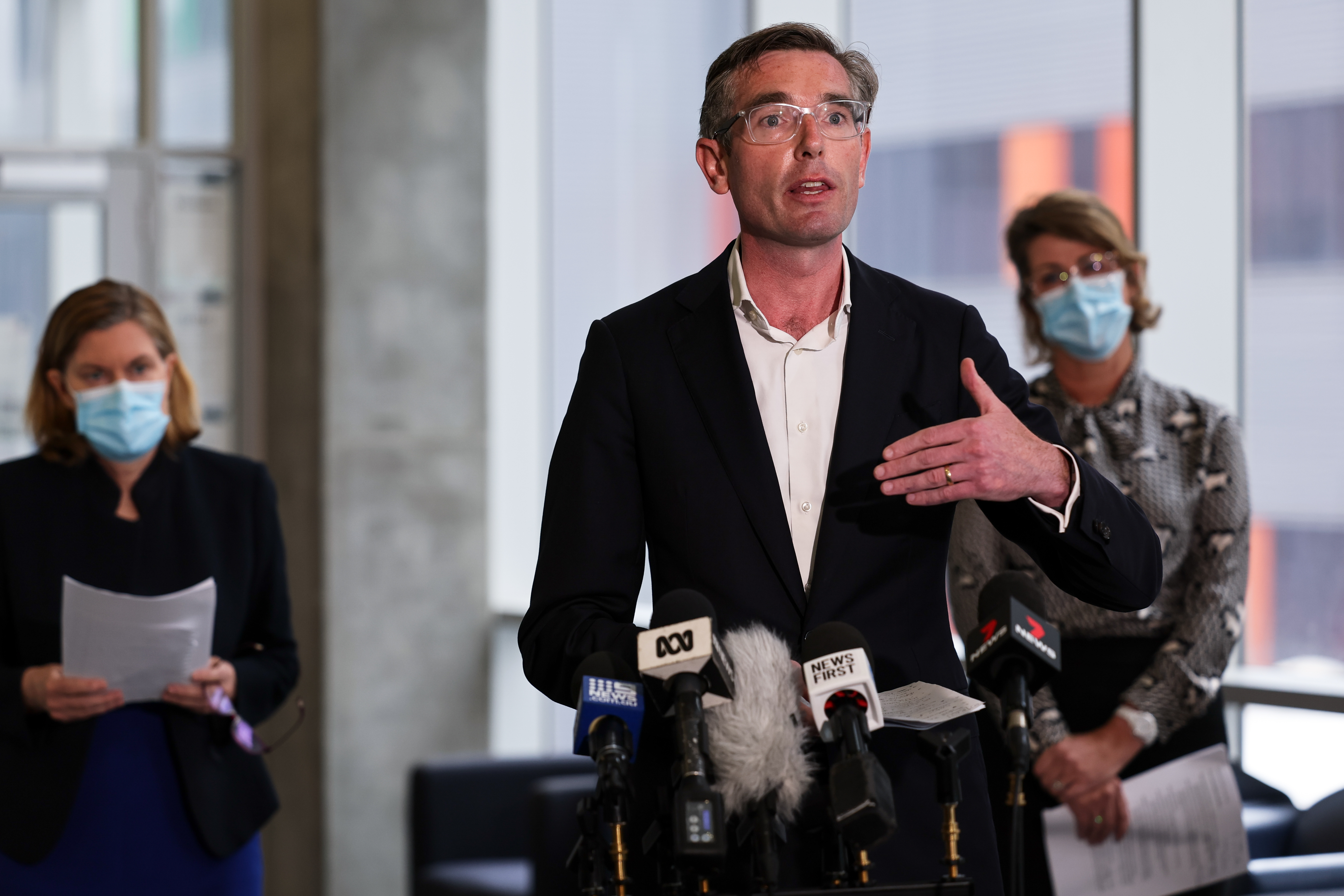 NSW Premier Dominic Perrottet (centre) speaks to the media during a press conference in Sydney, Friday, January 7, 2022. NSW has halted singing in clubs and pubs for three weeks and will impose a triple-vaccination mandate for some people as it tries to slow the Omicron wave.