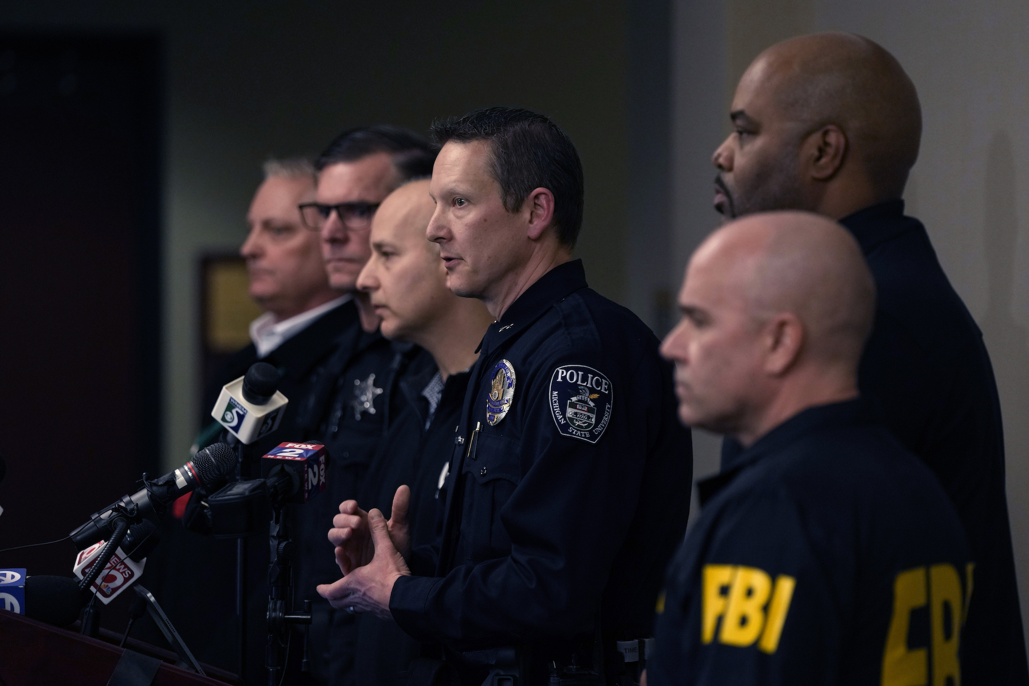 Michigan State University Interim Deputy Police Chief Chris Rozman, center, joins law enforcement officials while addressing the media early Tuesday.