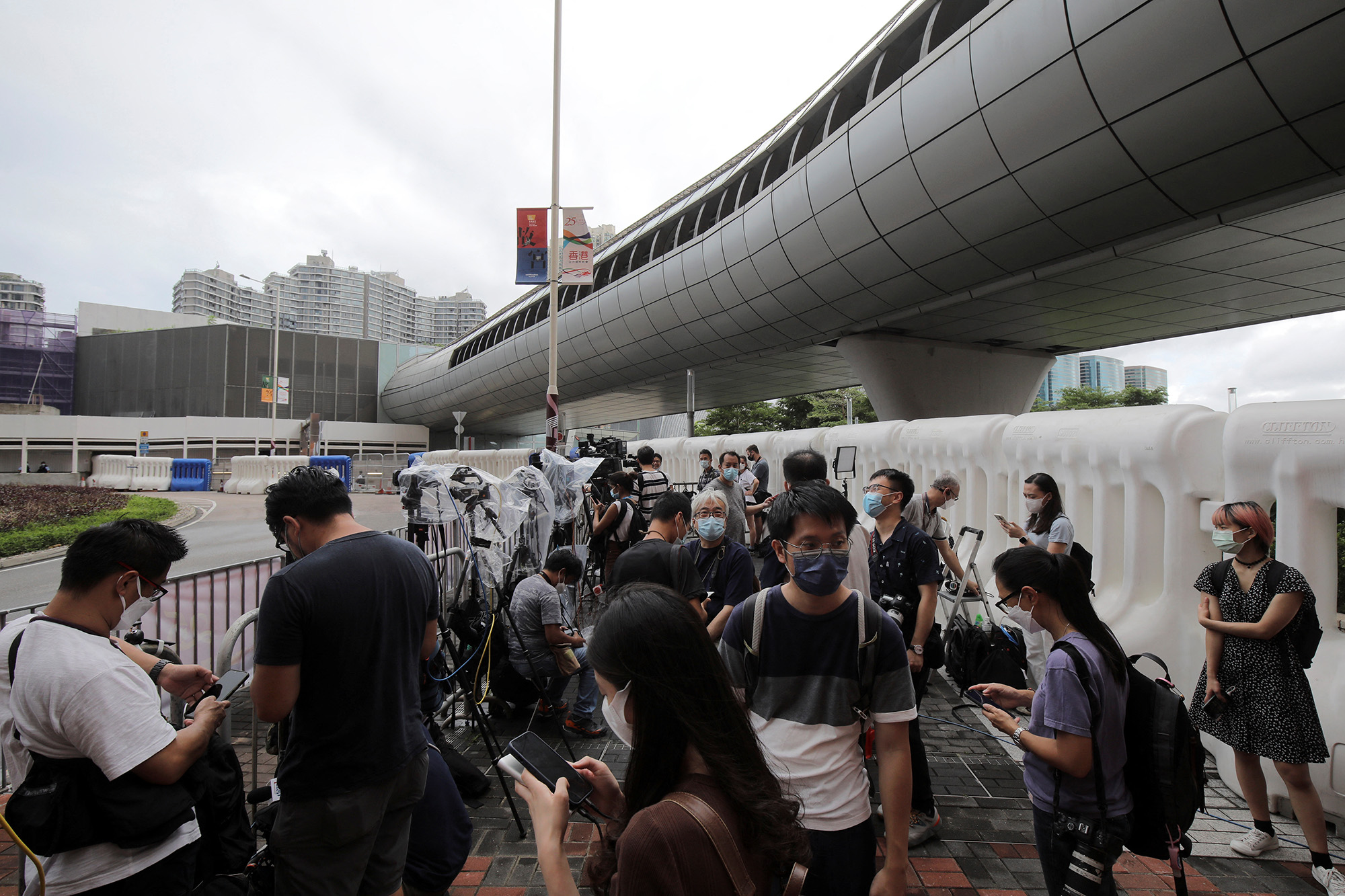 Journalists wait at a media position outside the Hong Kong West Kowloon railway station, before the 25th anniversary of the former British colony's handover to Chinese rule, in Hong Kong on June 30.