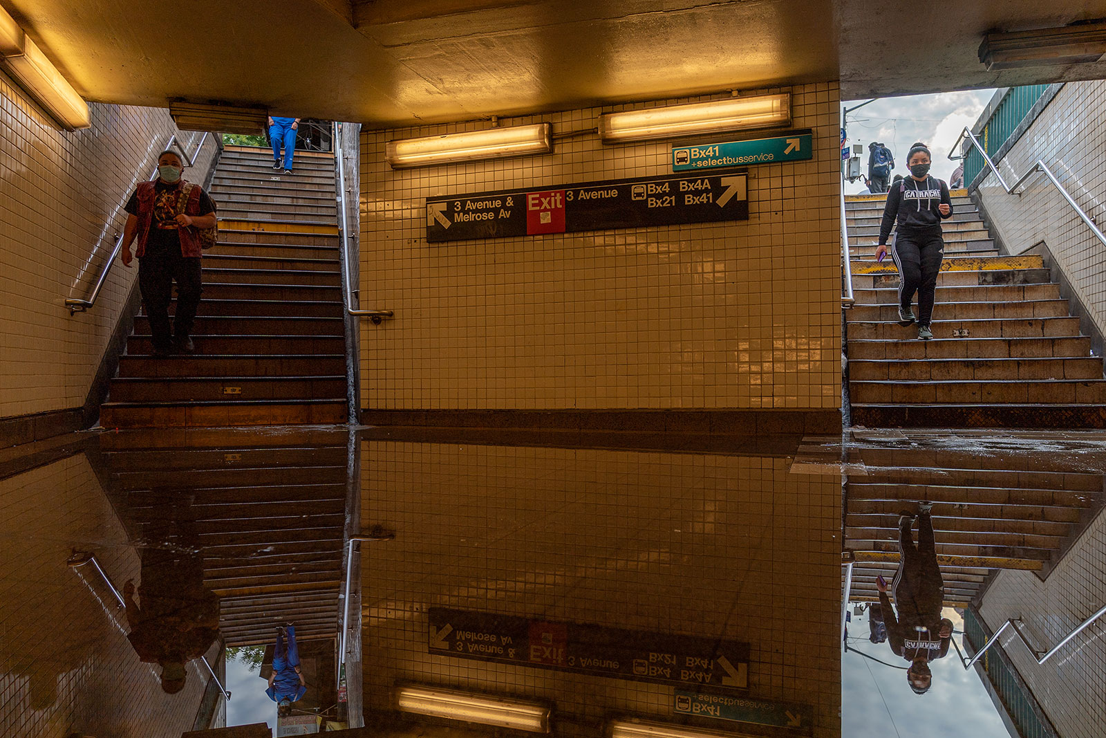 Commuters walk into a flooded subway station in New York on Sept. 2.