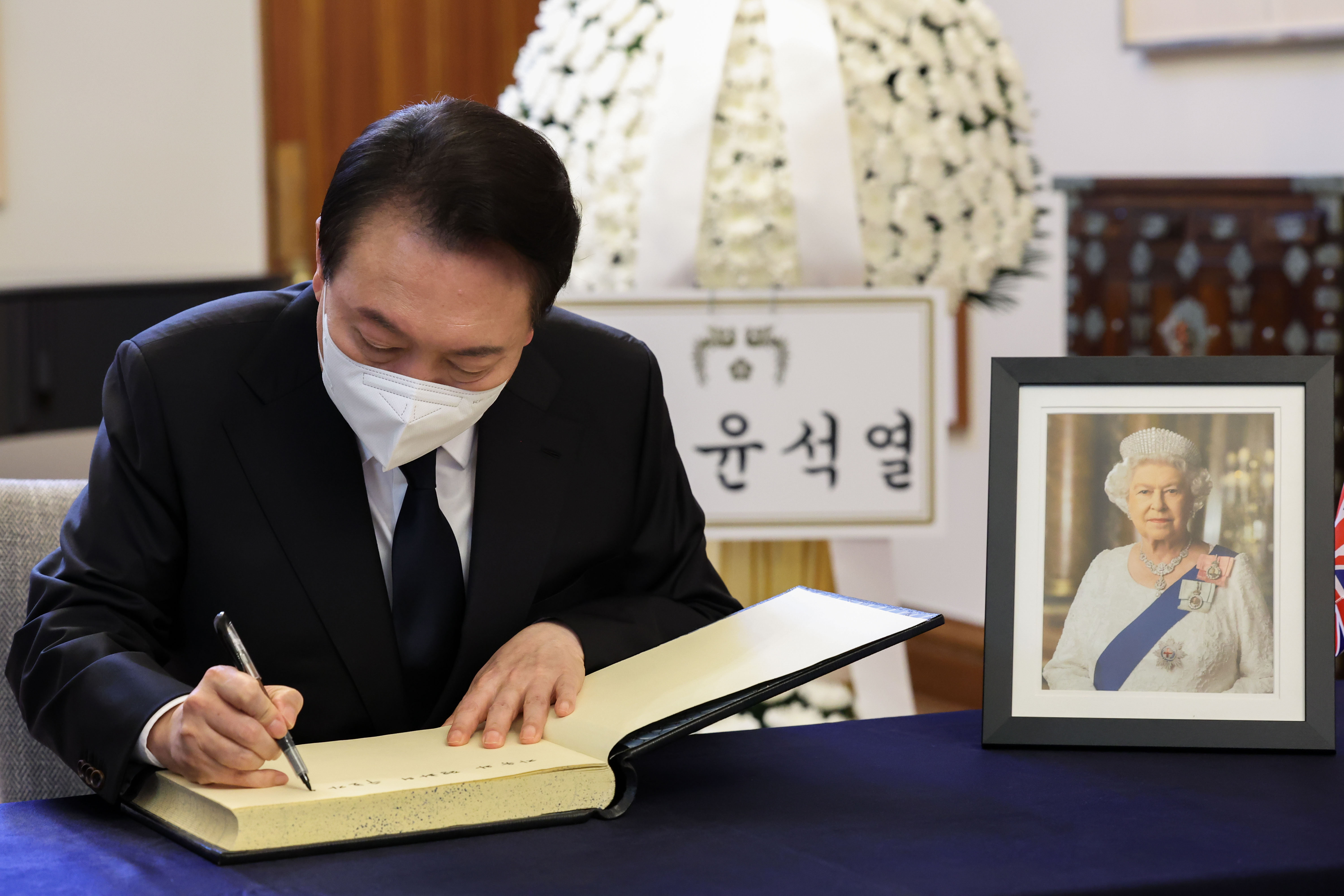 South Korean President Yoon Suk Yeol writes in a condolence book in honor of Queen Elizabeth II, on September 9, in Seoul, South Korea. 