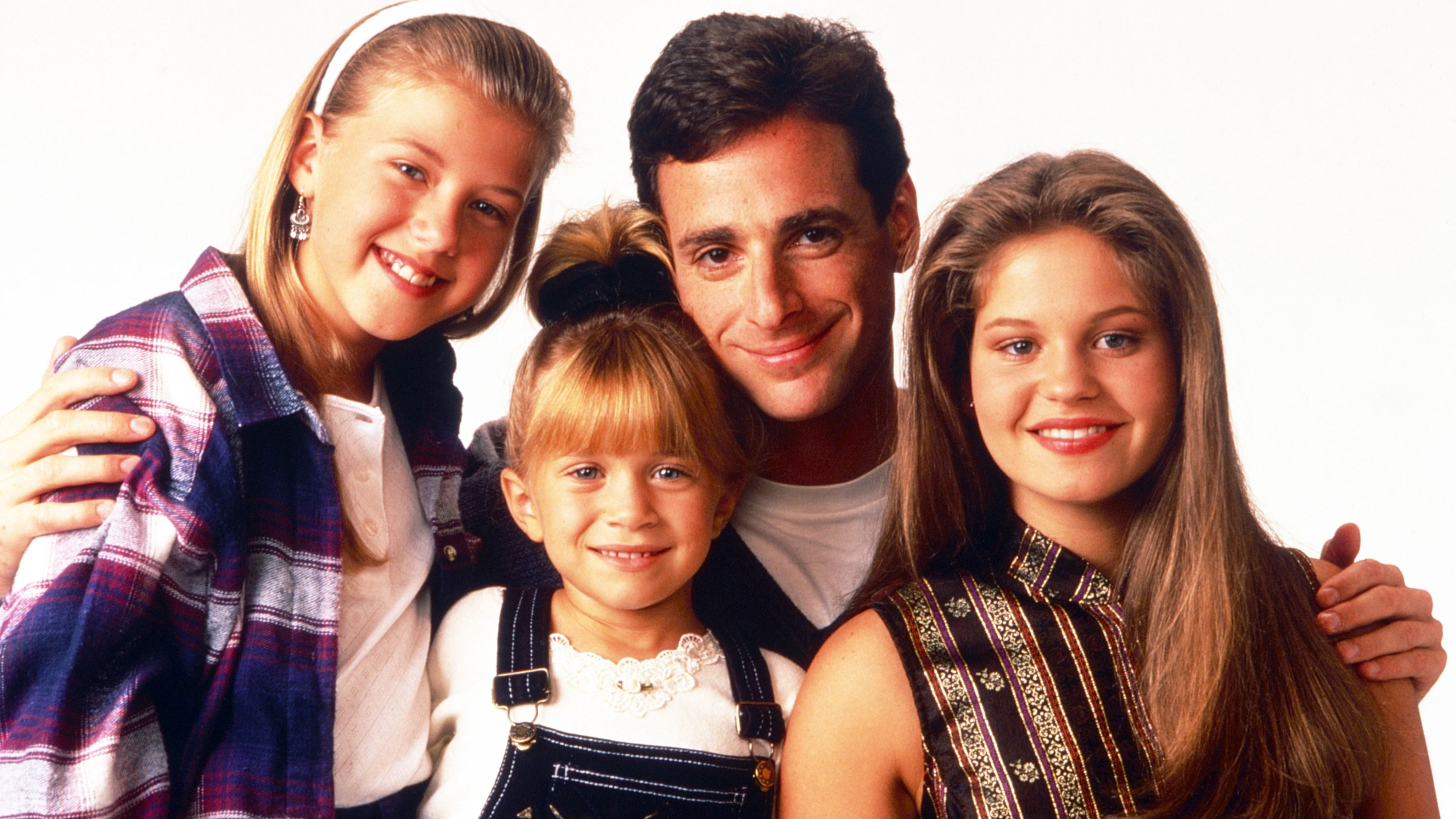Left to right: Jodie Sweetin, Mary-Kate Olsen, Bob Saget, and Candace Cameron Bure pose for a promotional photo for the TV show Full House in 1993.