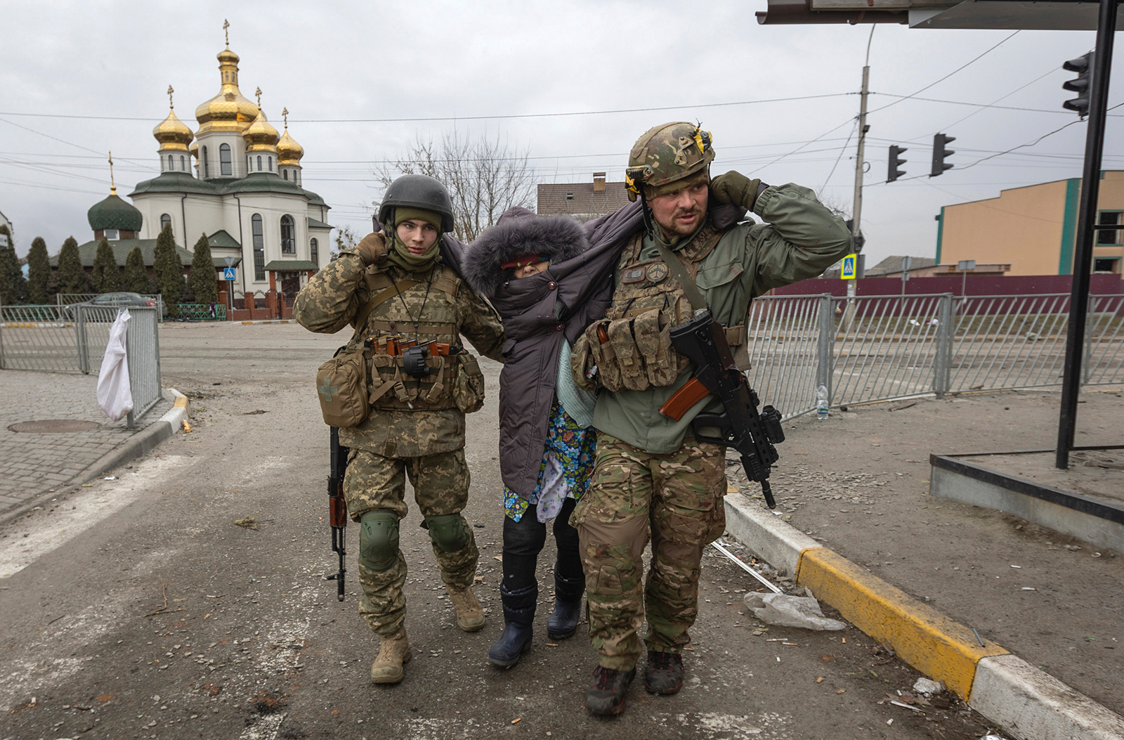 Ukrainian servicemen help an elderly woman, in the town of Irpin, Ukraine, on March 6.