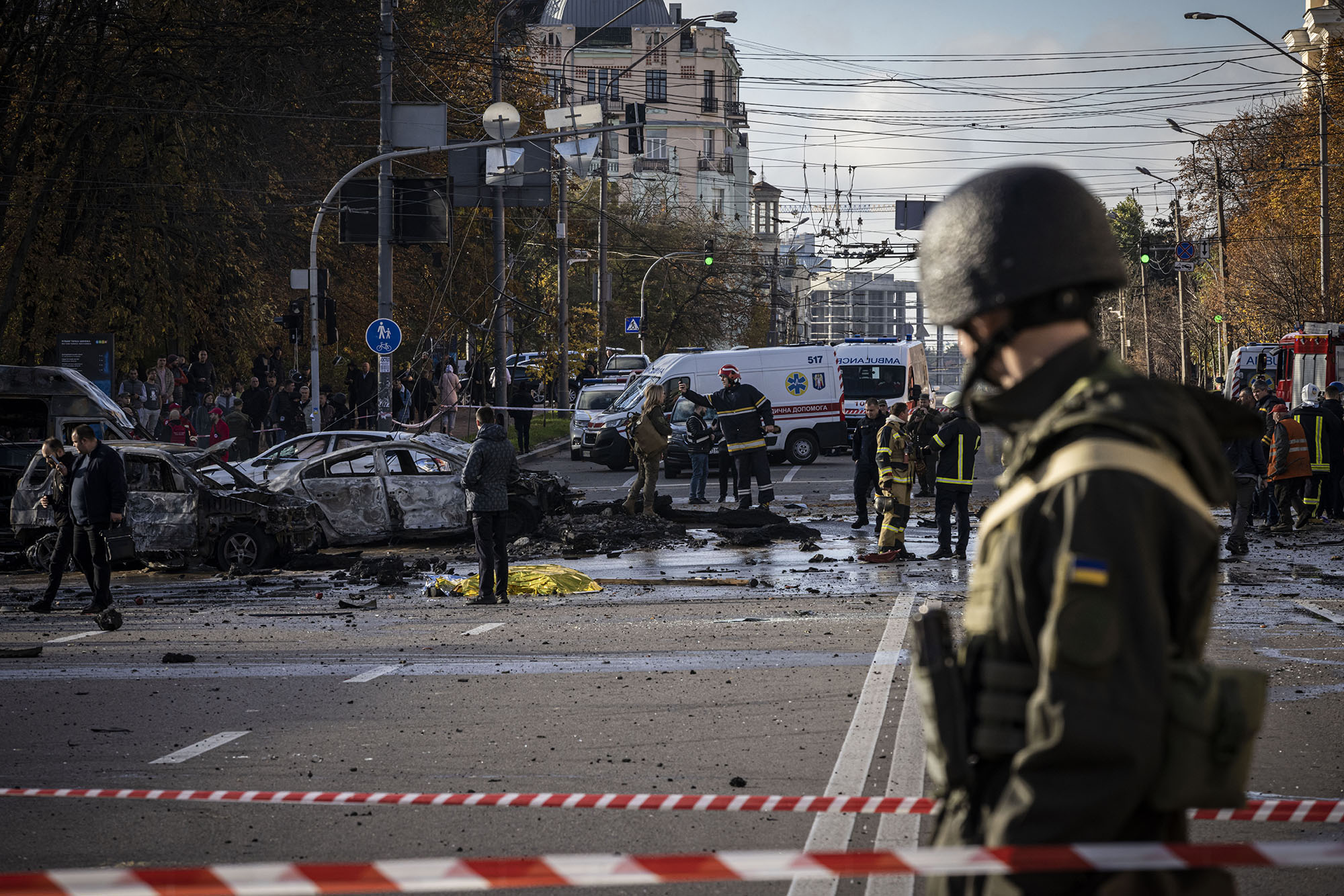 Emergency service personnel attend to the site of a blast on October 10, in Kyiv, Ukraine.