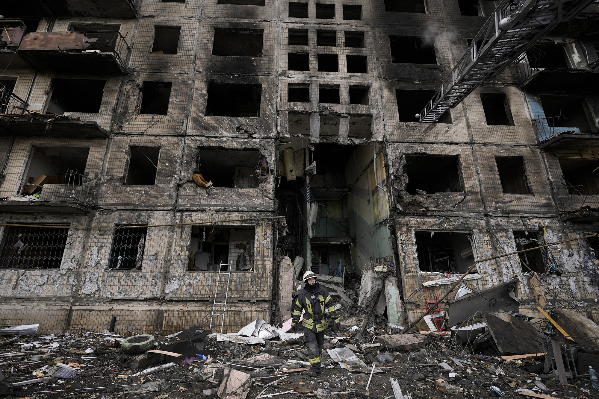 A Ukrainian firefighter works at an apartment building after it was hit by artillery shelling in Kyiv, Ukraine, on March 14.