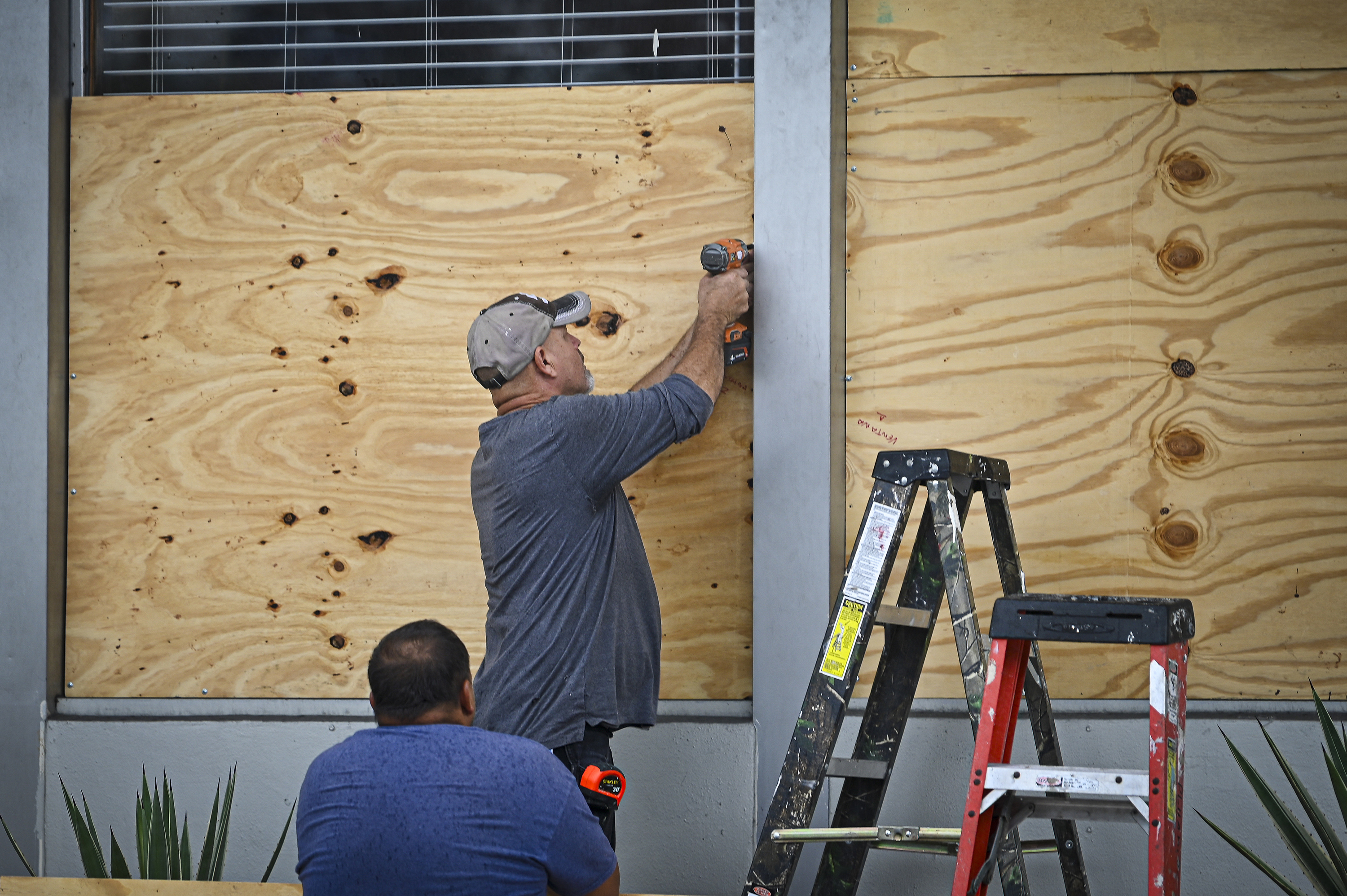 People board up a window in Tampa, Florida, on August 29, as the city prepares for Hurricane Idalia. 