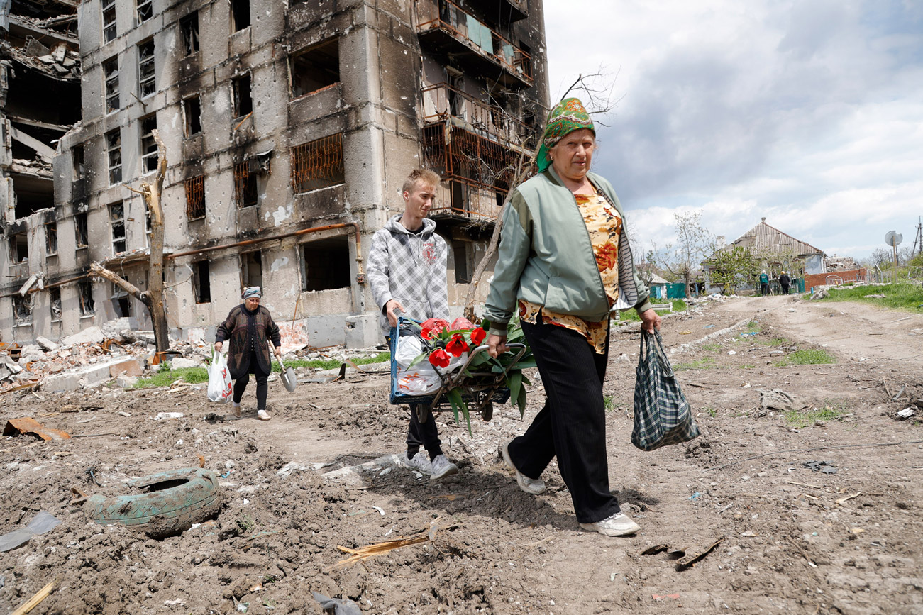 People walk past a destroyed apartment building in Mariupol on May 2.