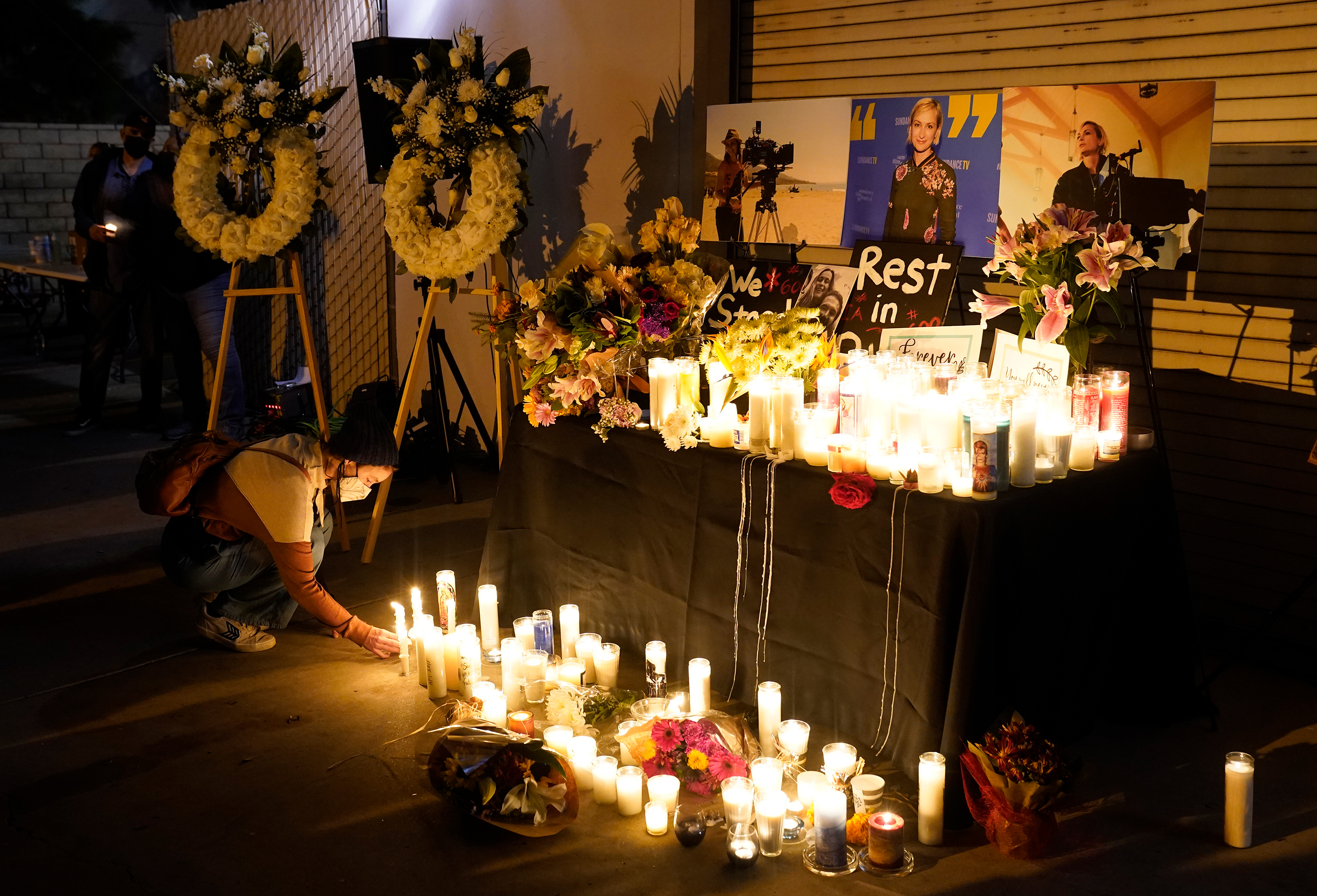 A woman lights a candle for cinematographer Helena Hutchins on Sunday, October 24 in Burbank, California. 