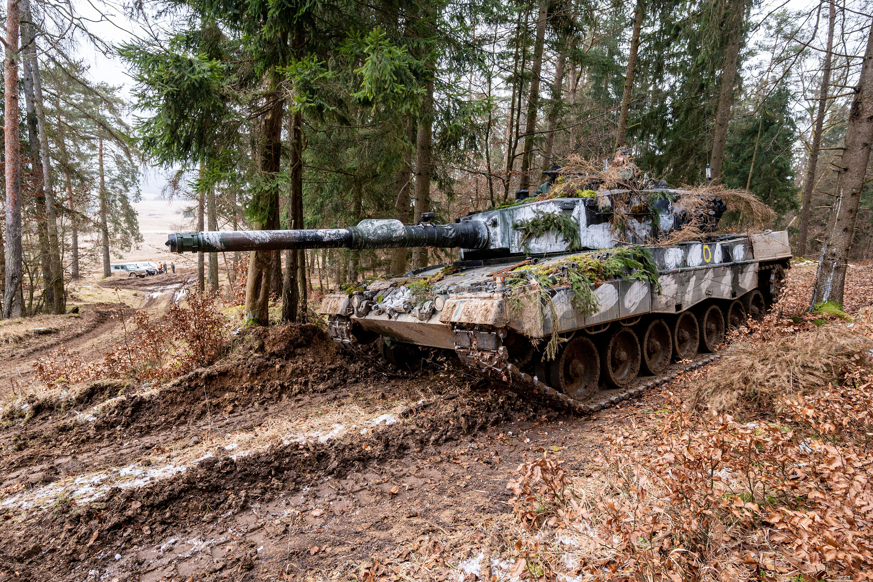 A Polish Leopard 2 tank stands in a wooded area during a military exercise in Hohenfels, Germany, in January 2022.
