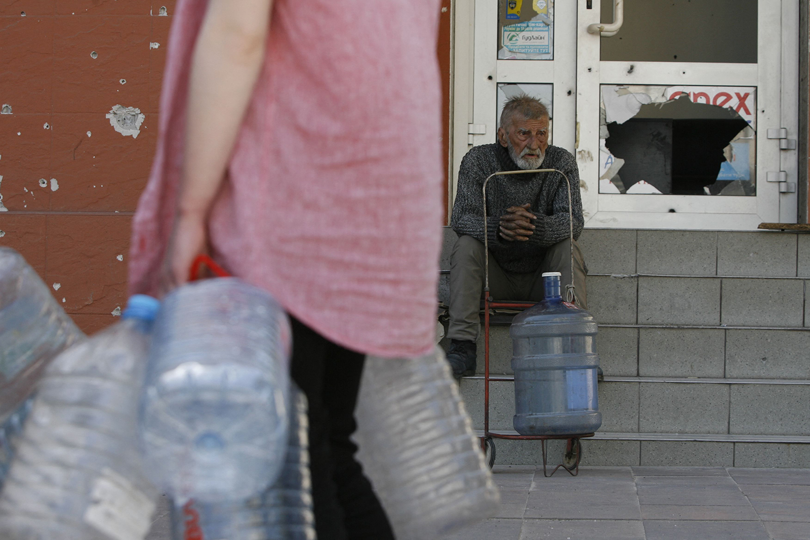 A man waits to get water in Mariupol on May 30, amid the ongoing Russian military action in Ukraine.