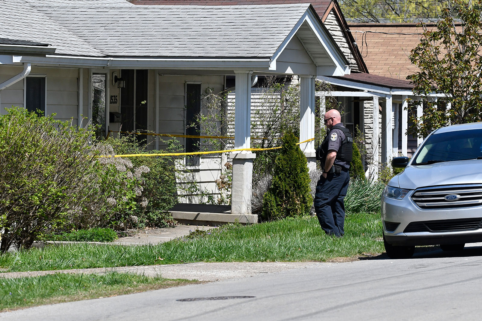 A Louisville Metro Police officer stands outside of the home of the suspected shooter in a neighborhood in Louisville, Kentucky, on April 10. 