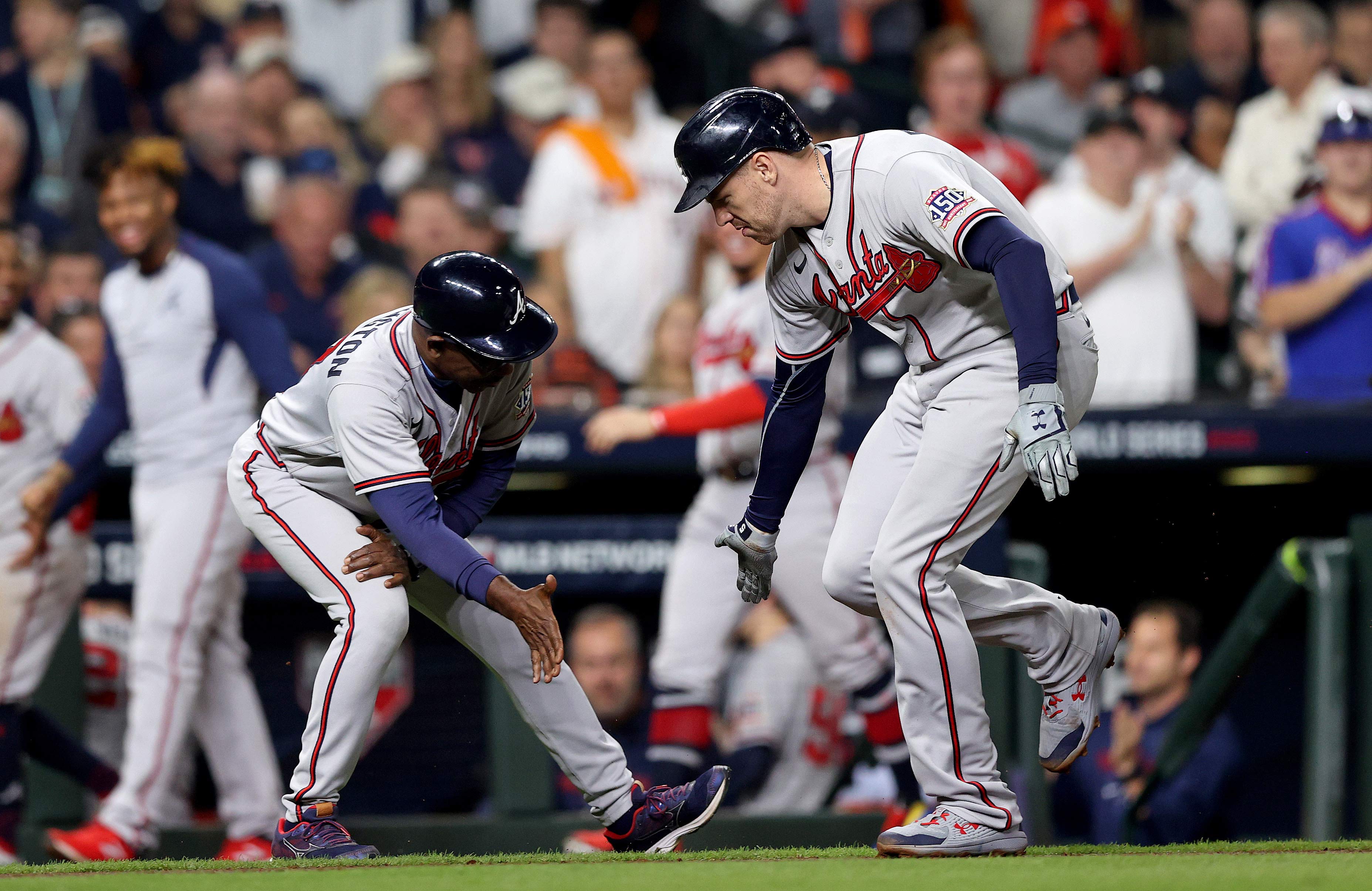 Freddie Freeman of the Braves is congratulated by third base coach Ron Washington after hitting a solo home run during the seventh inning in Game 6.