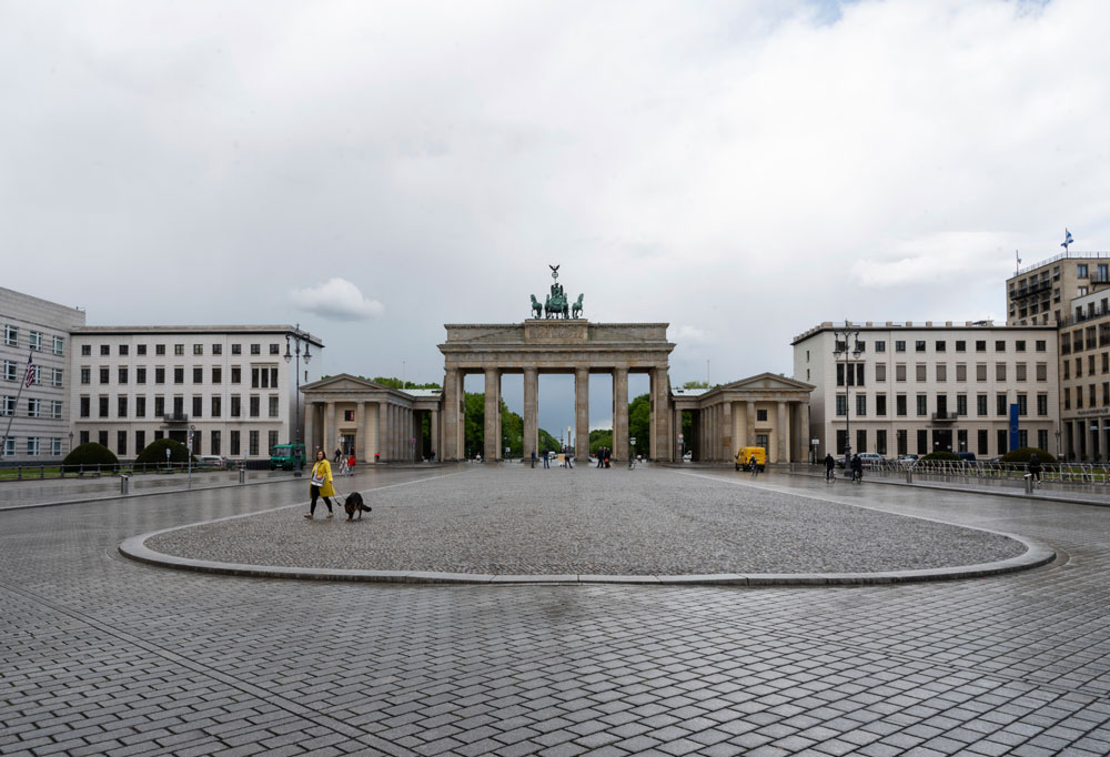A few people walk on Pariser Platz in front of the Brandenburg Gate in Berlin on Tuesday, March 5.