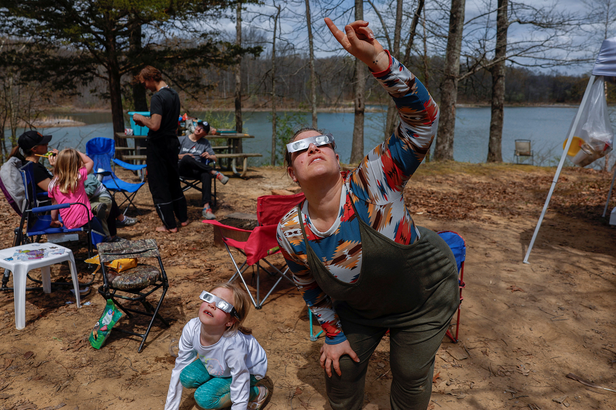 Brittany Sunderman, right, and Gianna Debenham, try out their eclipse viewing glasses at their campsite a day ahead of the eclipse event at Camp Carew in Makanda, Illinois, on April 7, 2024.