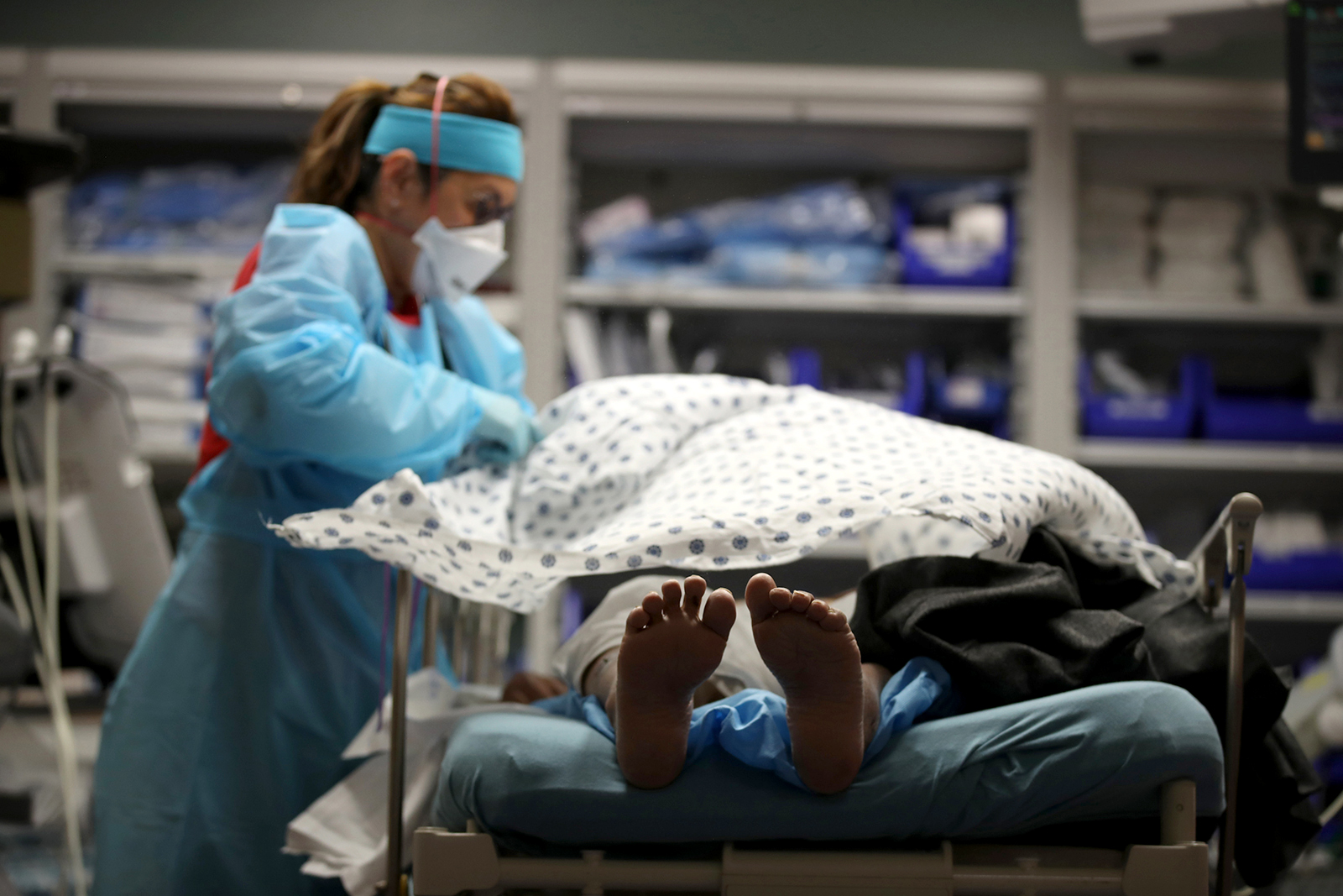 A nurse places a blanket over a patient that had just been admitted to the emergency room at Regional Medical Center in San Jose, California on May 21.