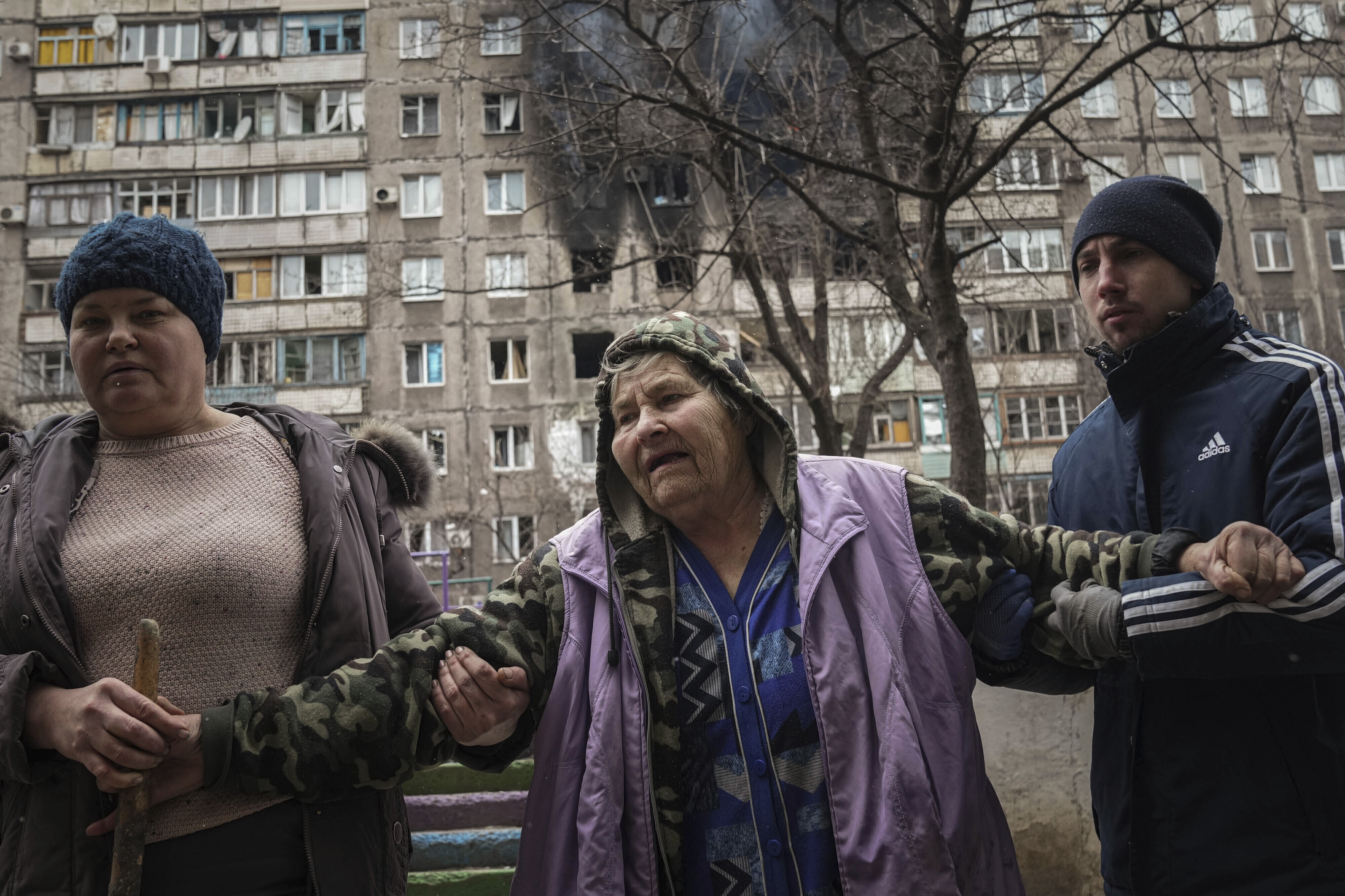 People help an elderly woman in the streets of Mariupol, Ukraine, on March 7.