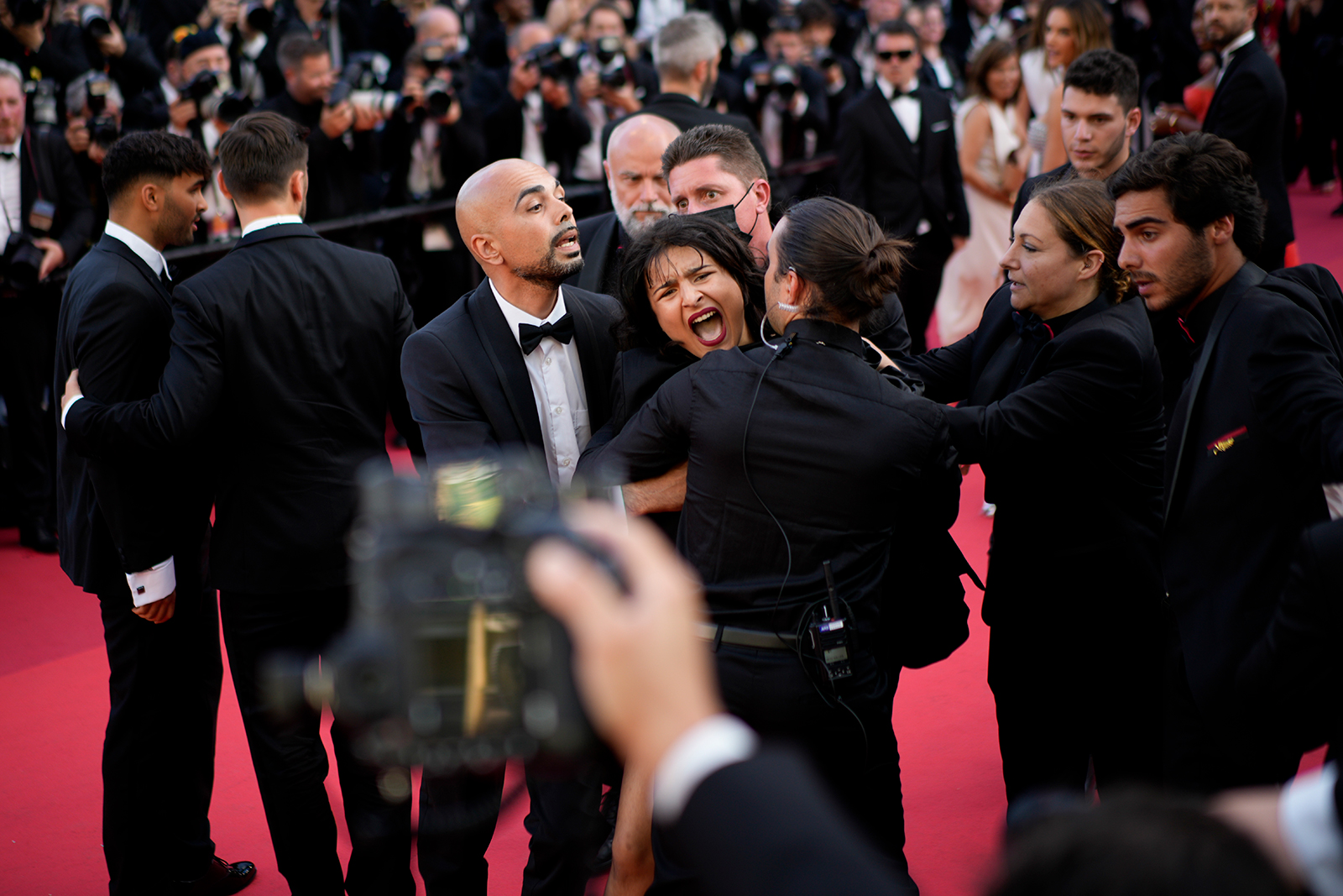 A protester wearing body paint that reads "Stop Raping Us" in the color of the Ukrainian flag is removed from the red carpet at the Cannes film festival in France on May 20.