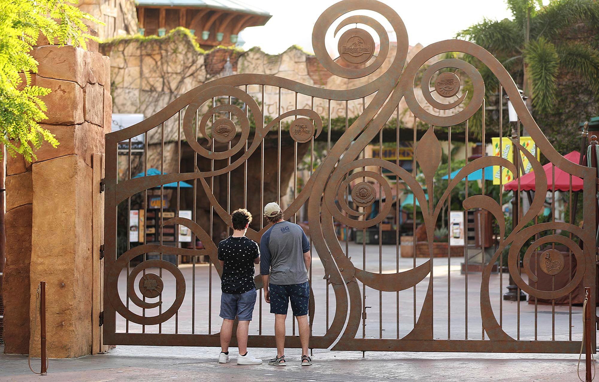 Guests peer through the closed gate to Universal's Islands of Adventure beside Universal CityWalk on May 14 in Orlando, Florida. 