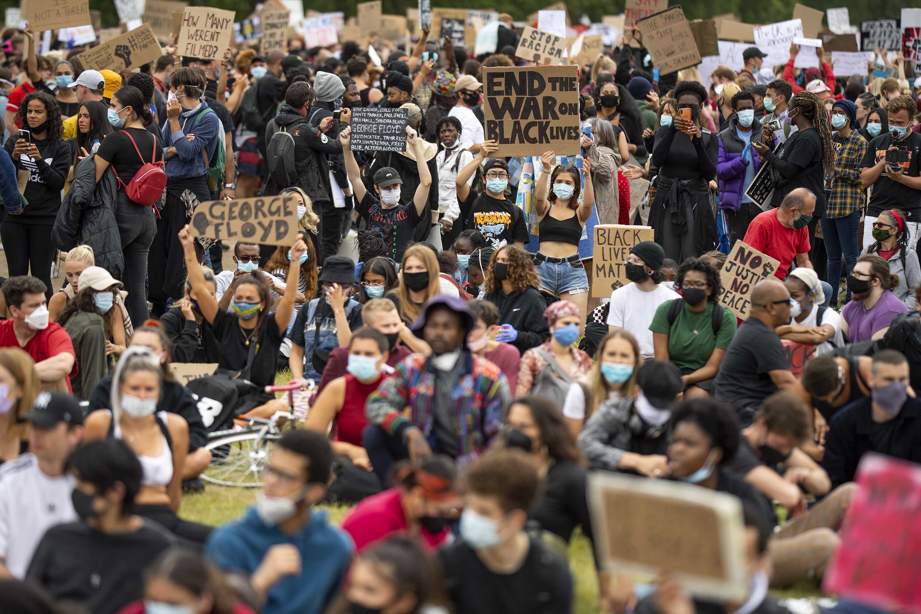 People hold up signs during a Black Lives Matter protest in London on June 3.